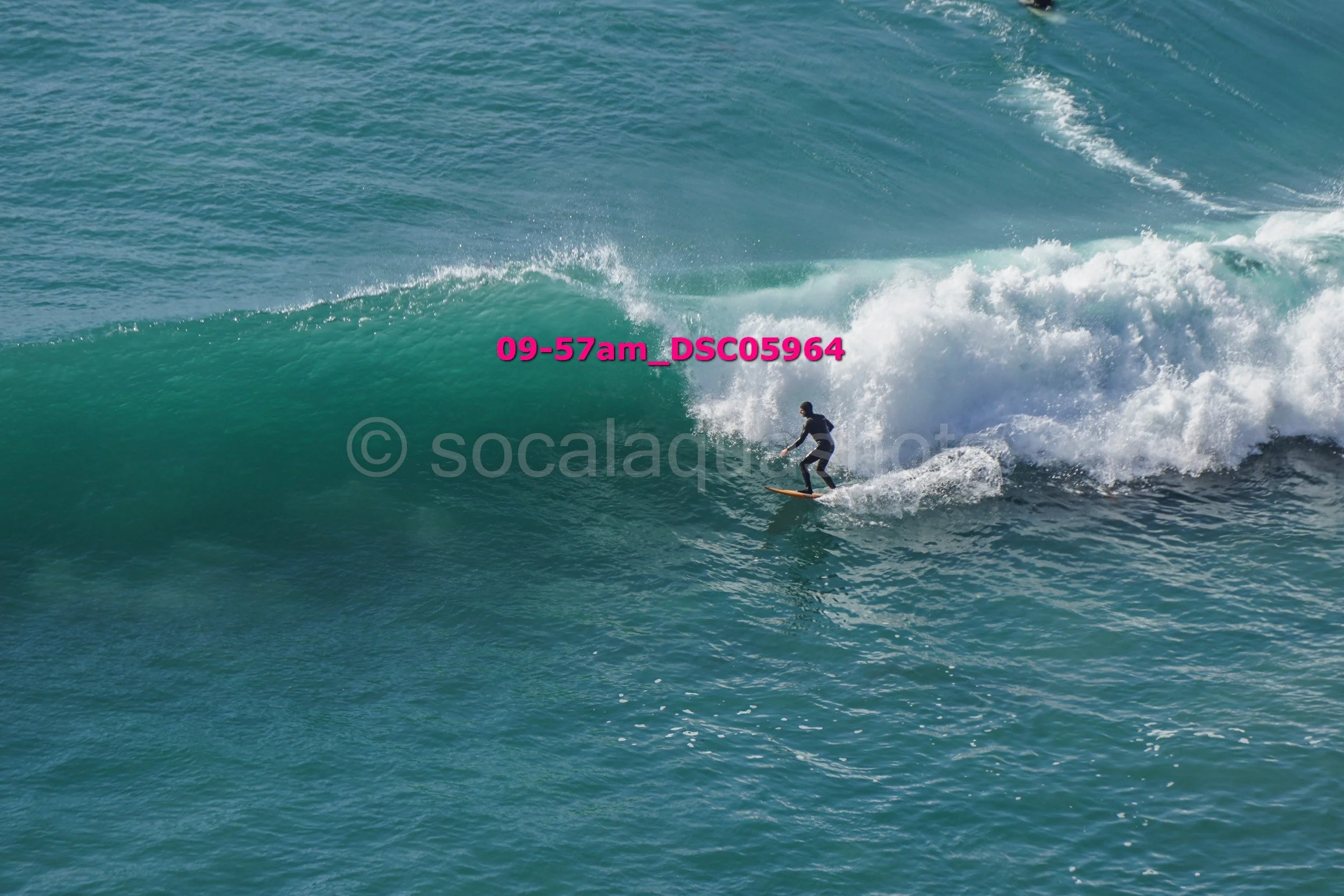 A person surfing on a large wave in the ocean.