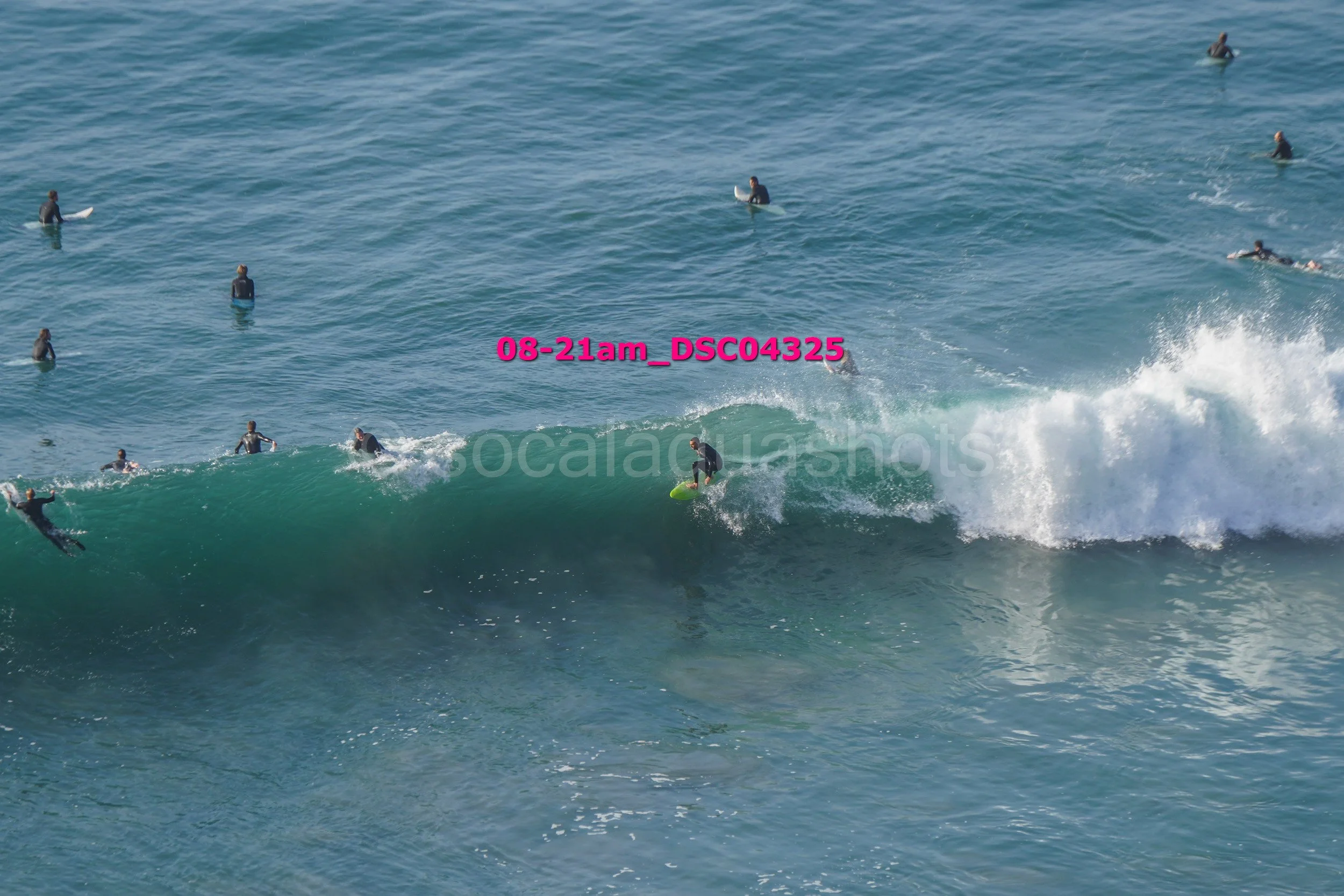 Surfer riding a wave with many people in the water