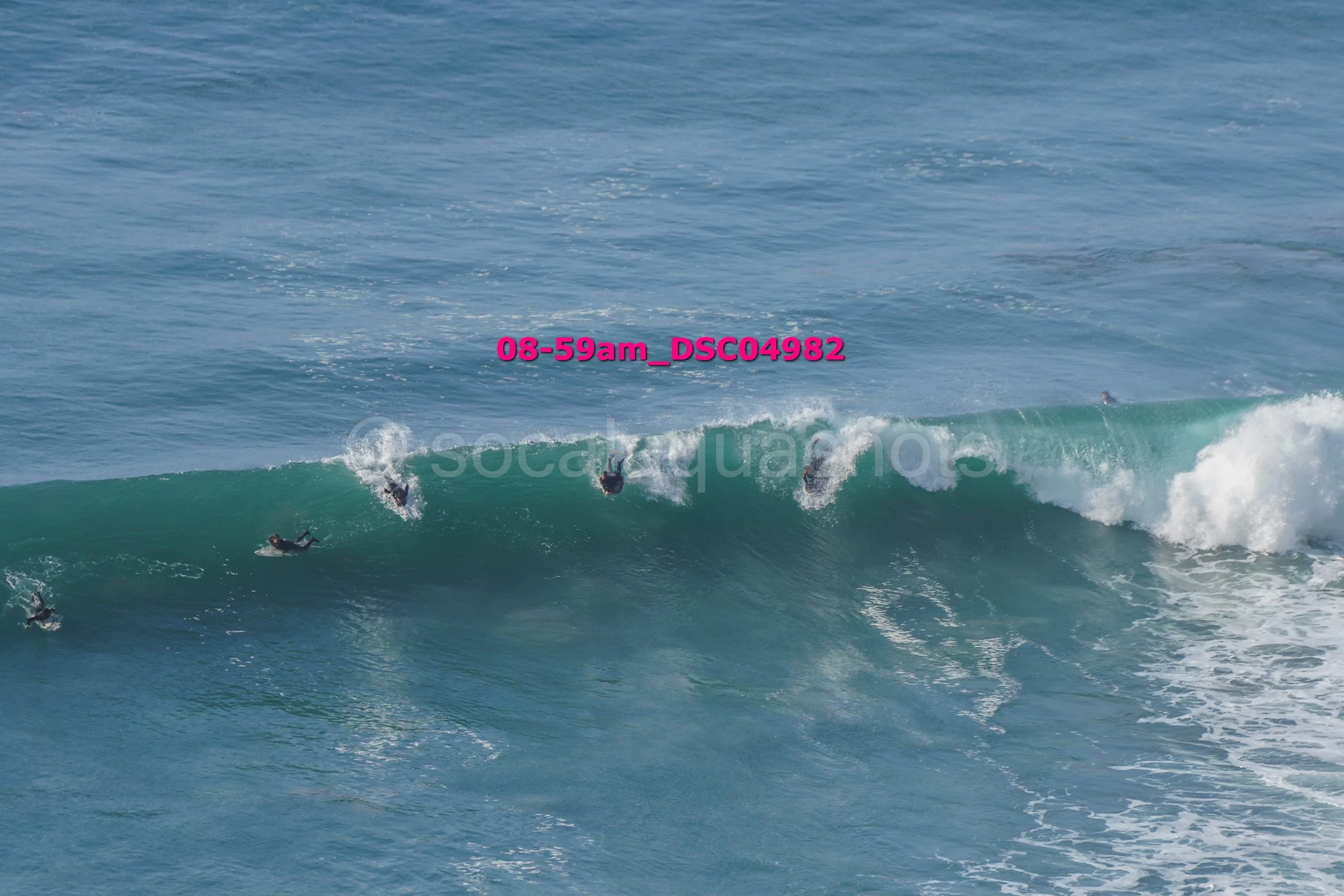 Surfers riding a large wave in the ocean.