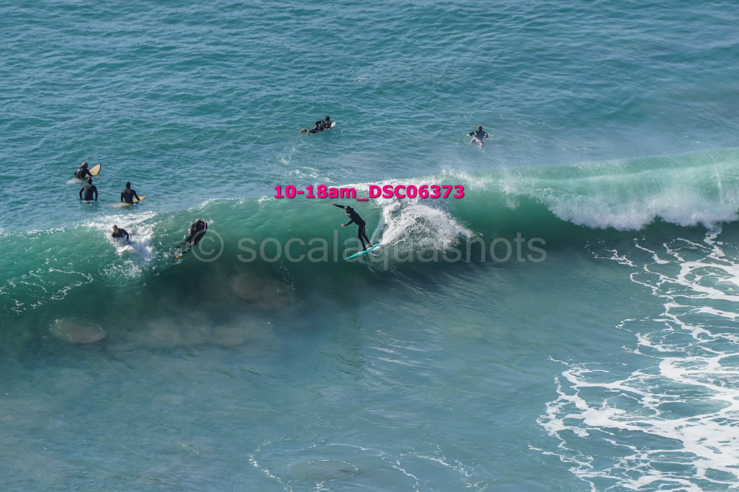 Surfers riding and waiting for waves in the ocean.