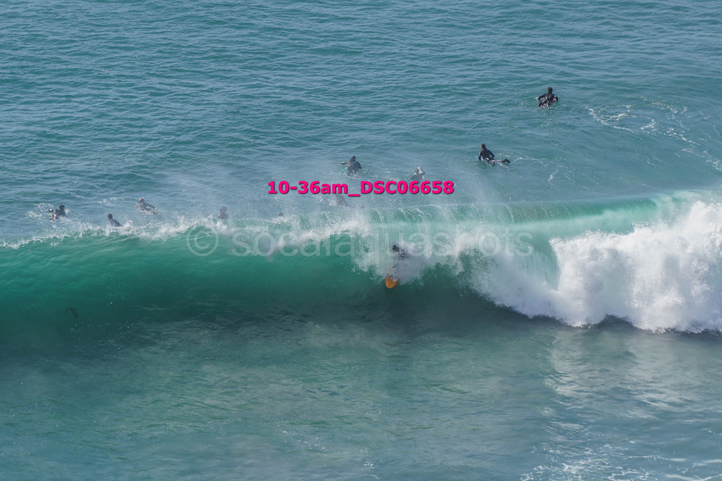 People surfing and swimming in the ocean with waves