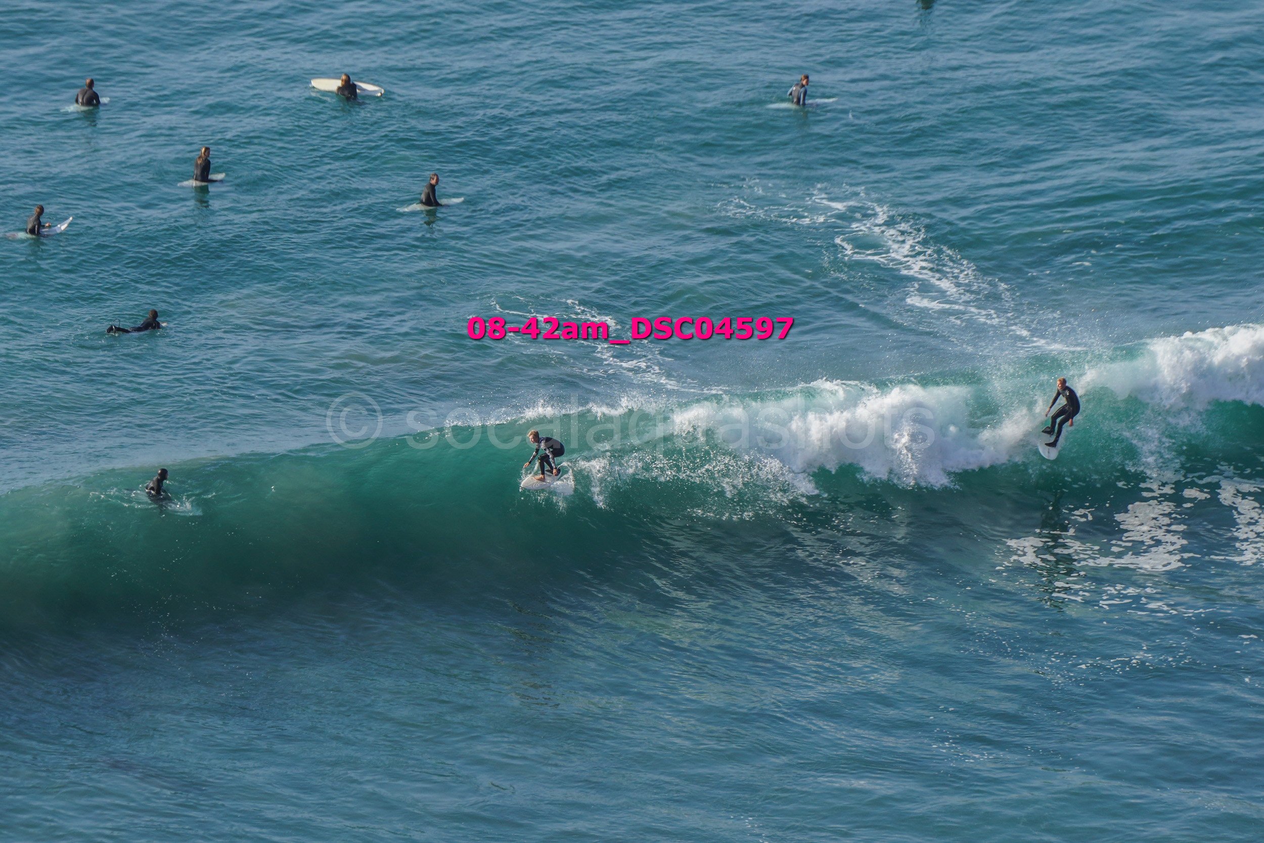 Surfers riding and waiting for waves in the ocean.