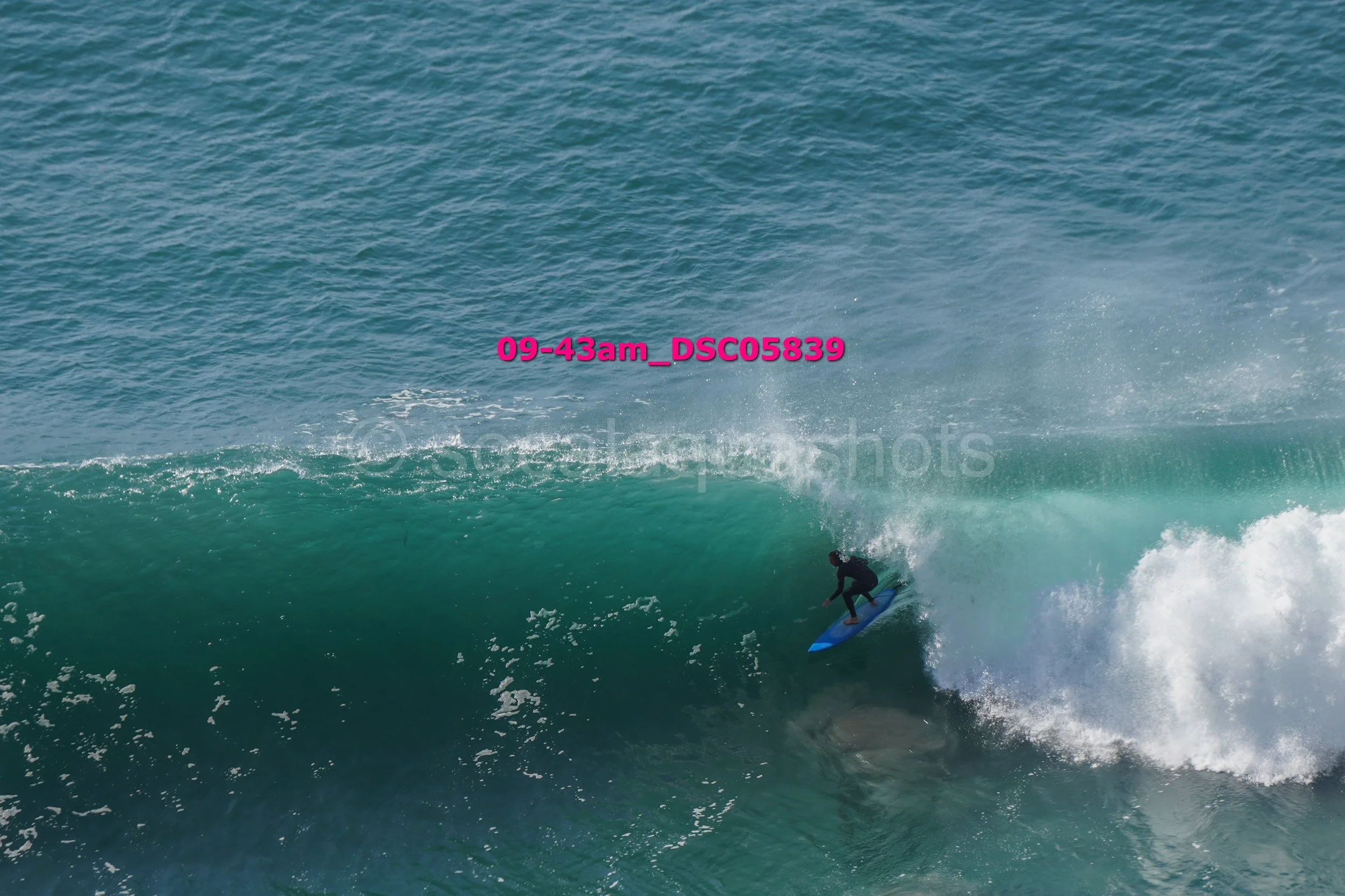 A person surfing on a wave in the ocean during the daytime.