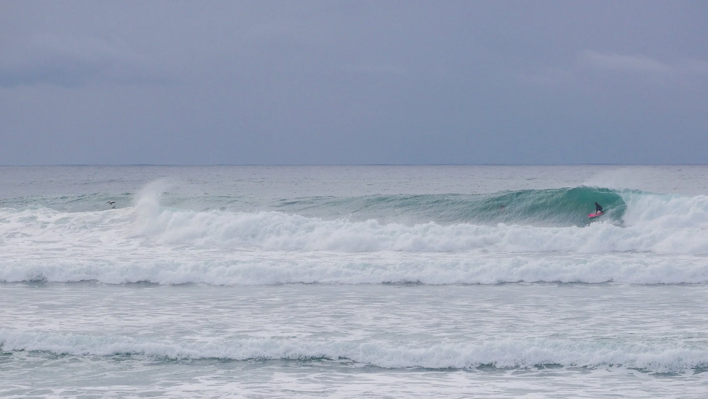 Surfer riding a wave on a blue ocean