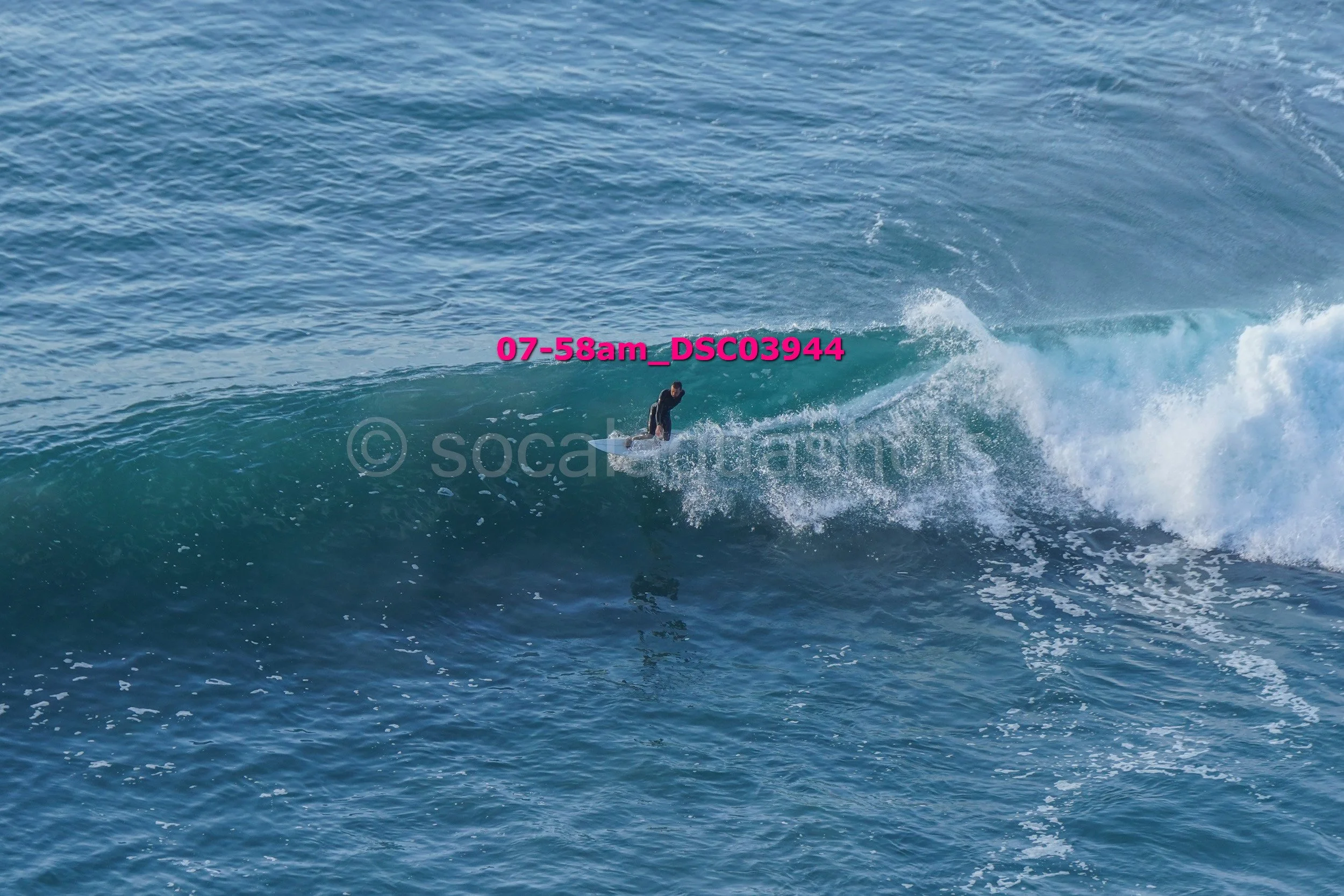 A surfer riding a wave in the ocean during daylight.