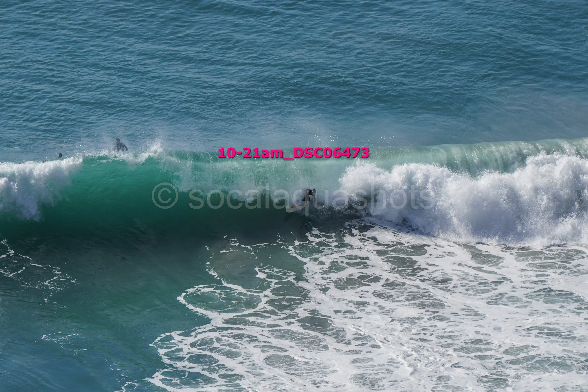People surfing on ocean waves with blue water and white foam.