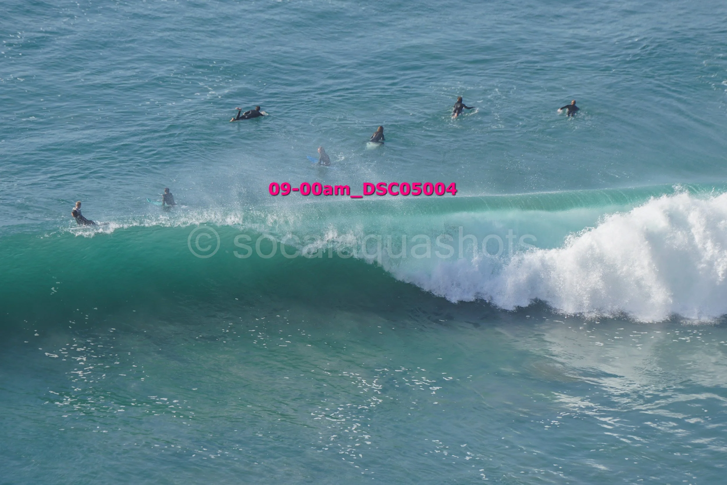 Surfers riding a large ocean wave in the water.