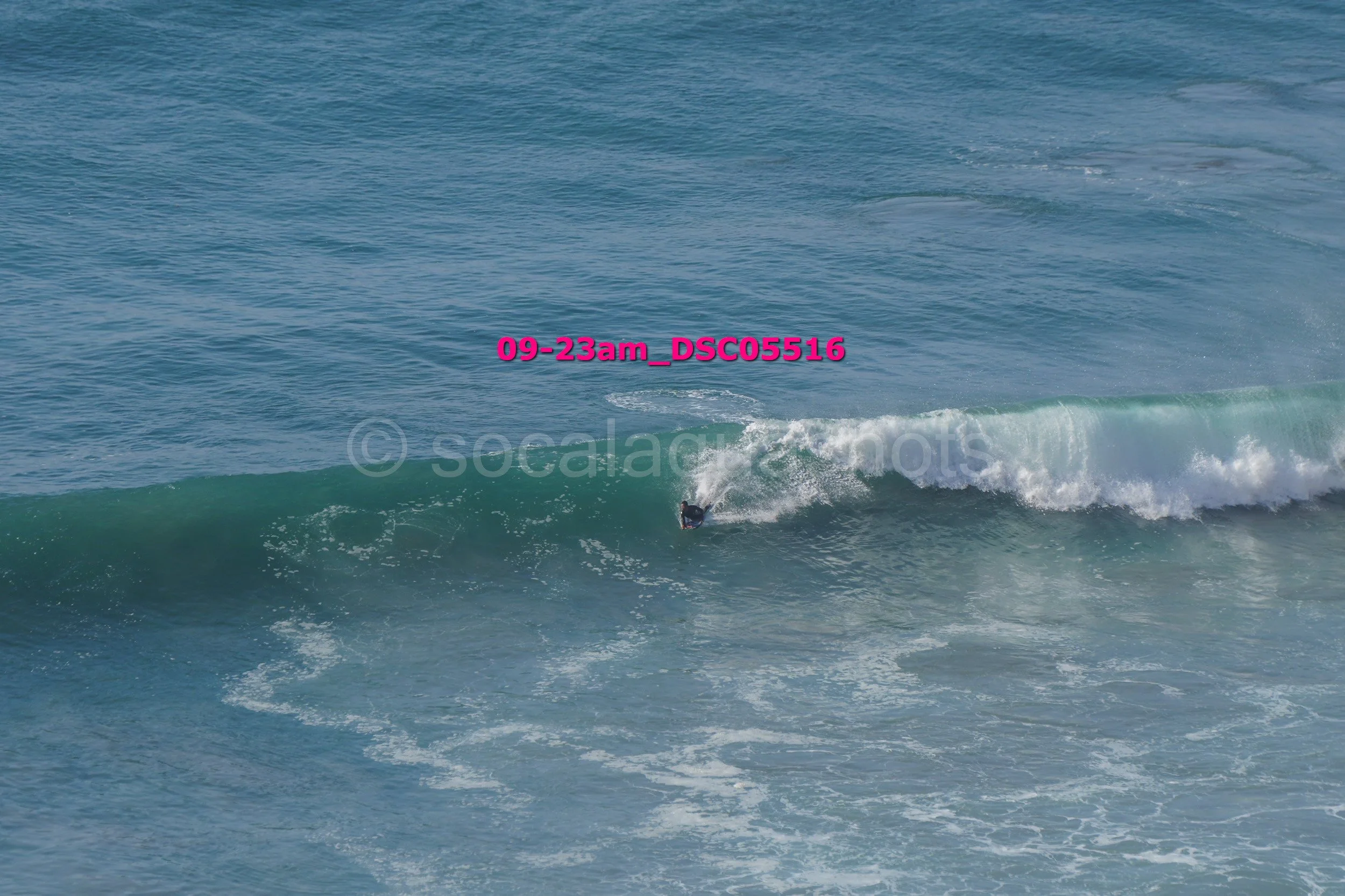 A person surfing on a wave in the ocean during daytime.