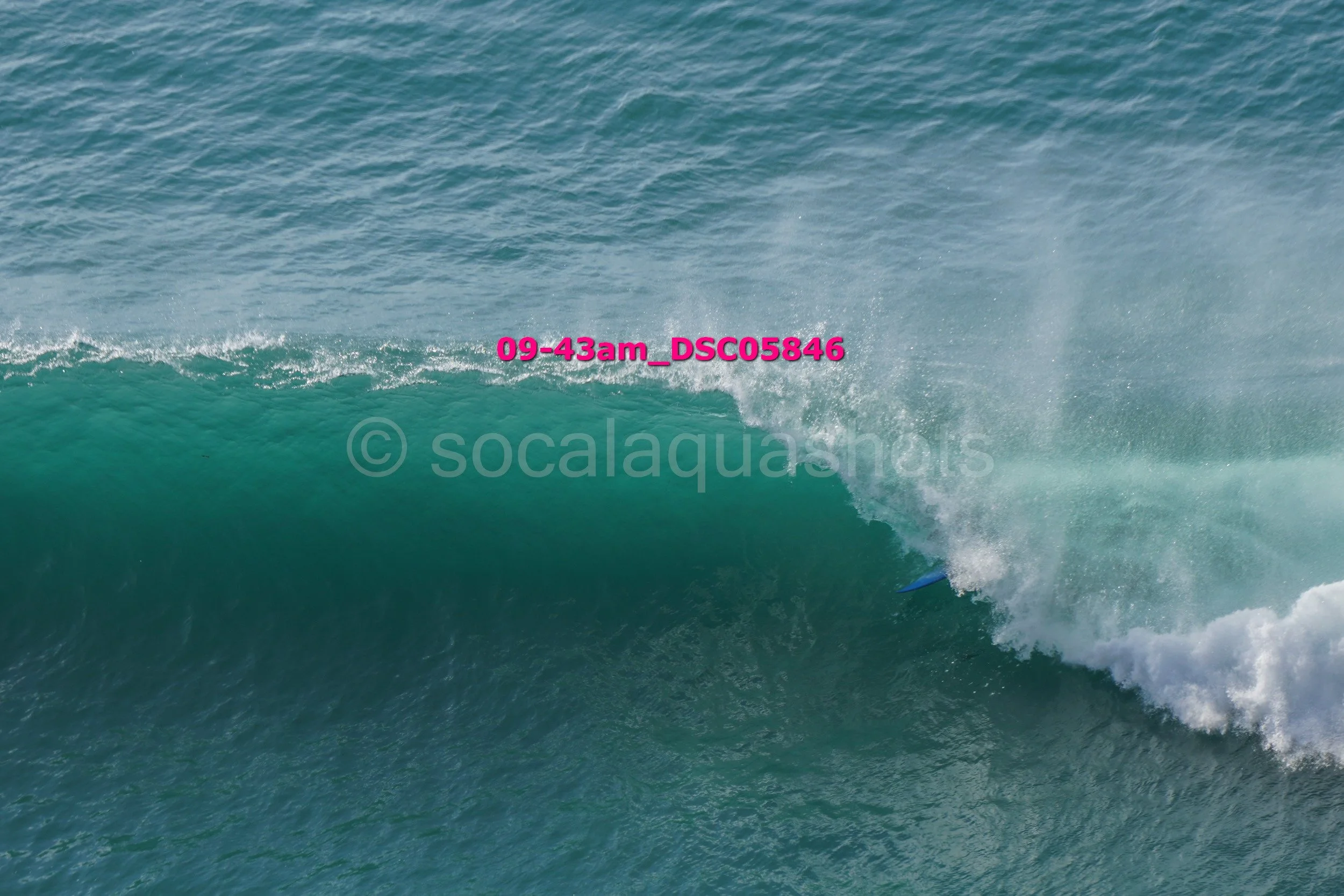 A surfer riding inside the barrel of a large ocean wave.