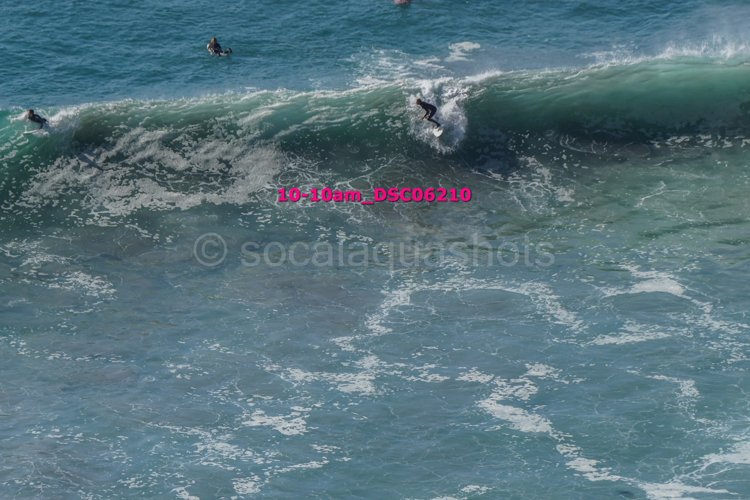 Surfers riding a large wave in the ocean.