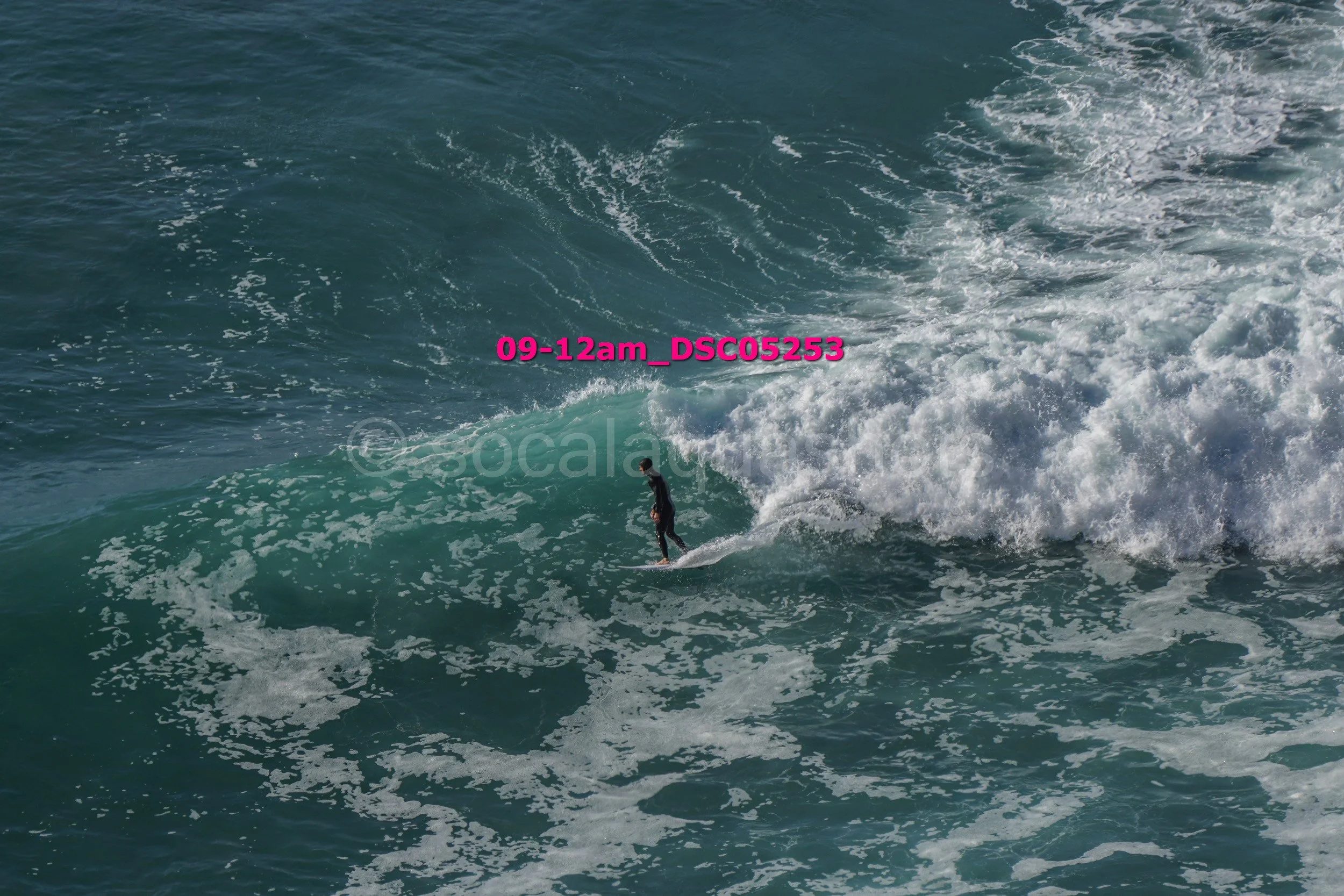 A person surfing on a wave in the ocean during the daytime.