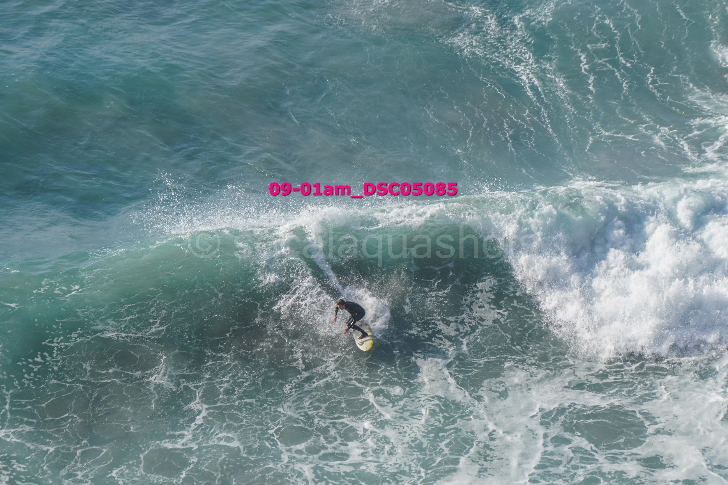 A person surfing on a large wave in the ocean.