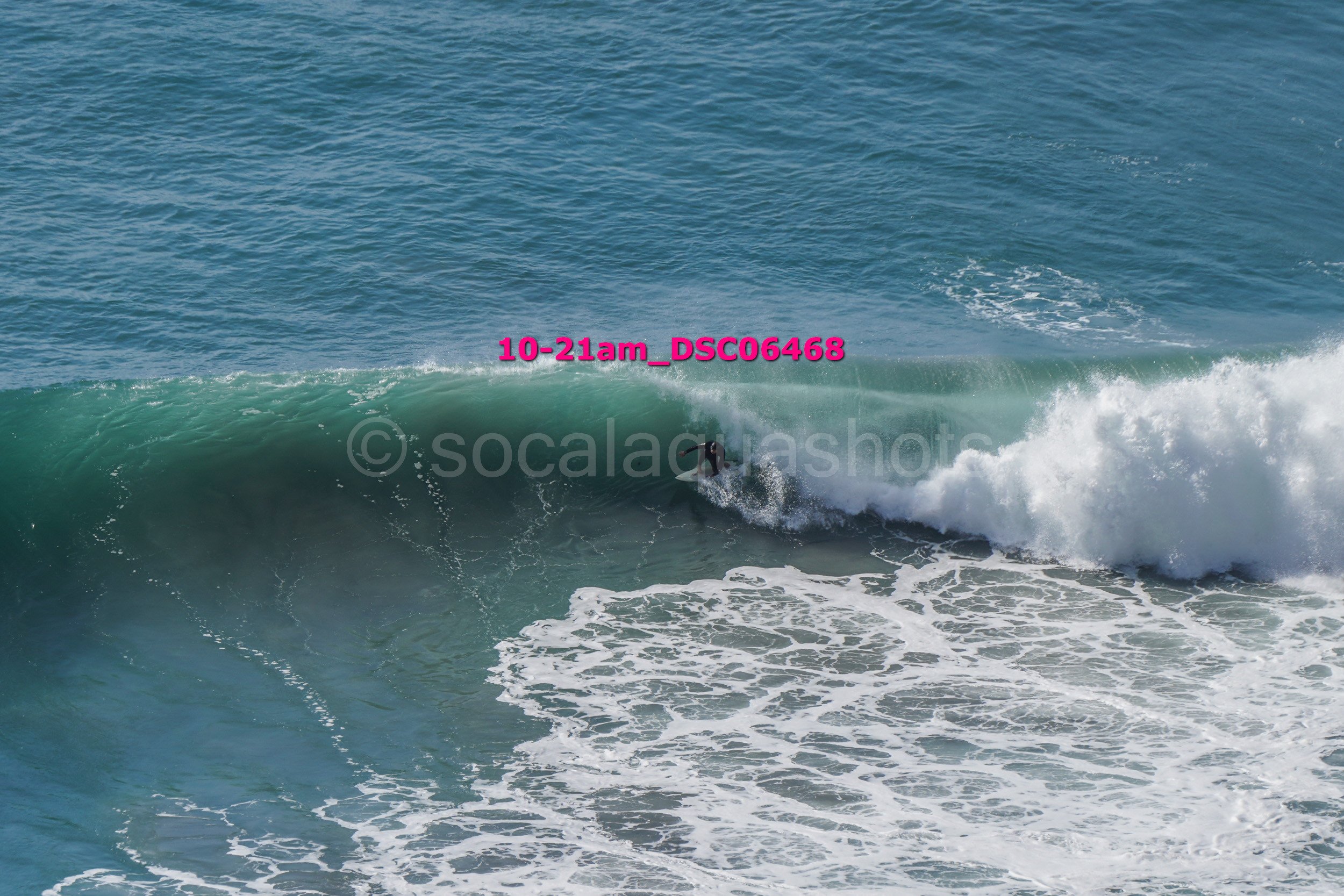A surfer riding a wave in the ocean during daytime.