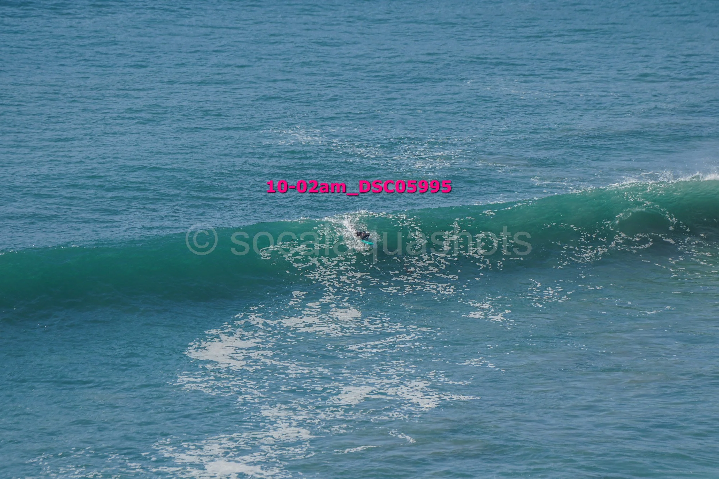 A person surfing on a wave in the ocean.