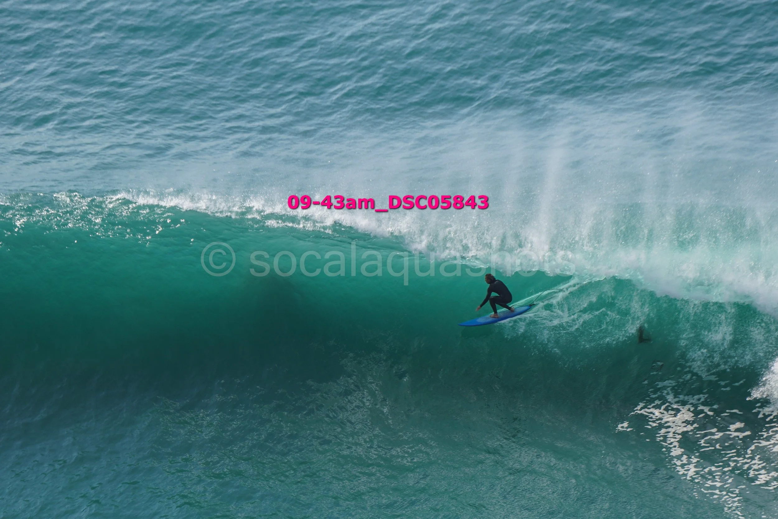 A person surfing on a large wave in the ocean.