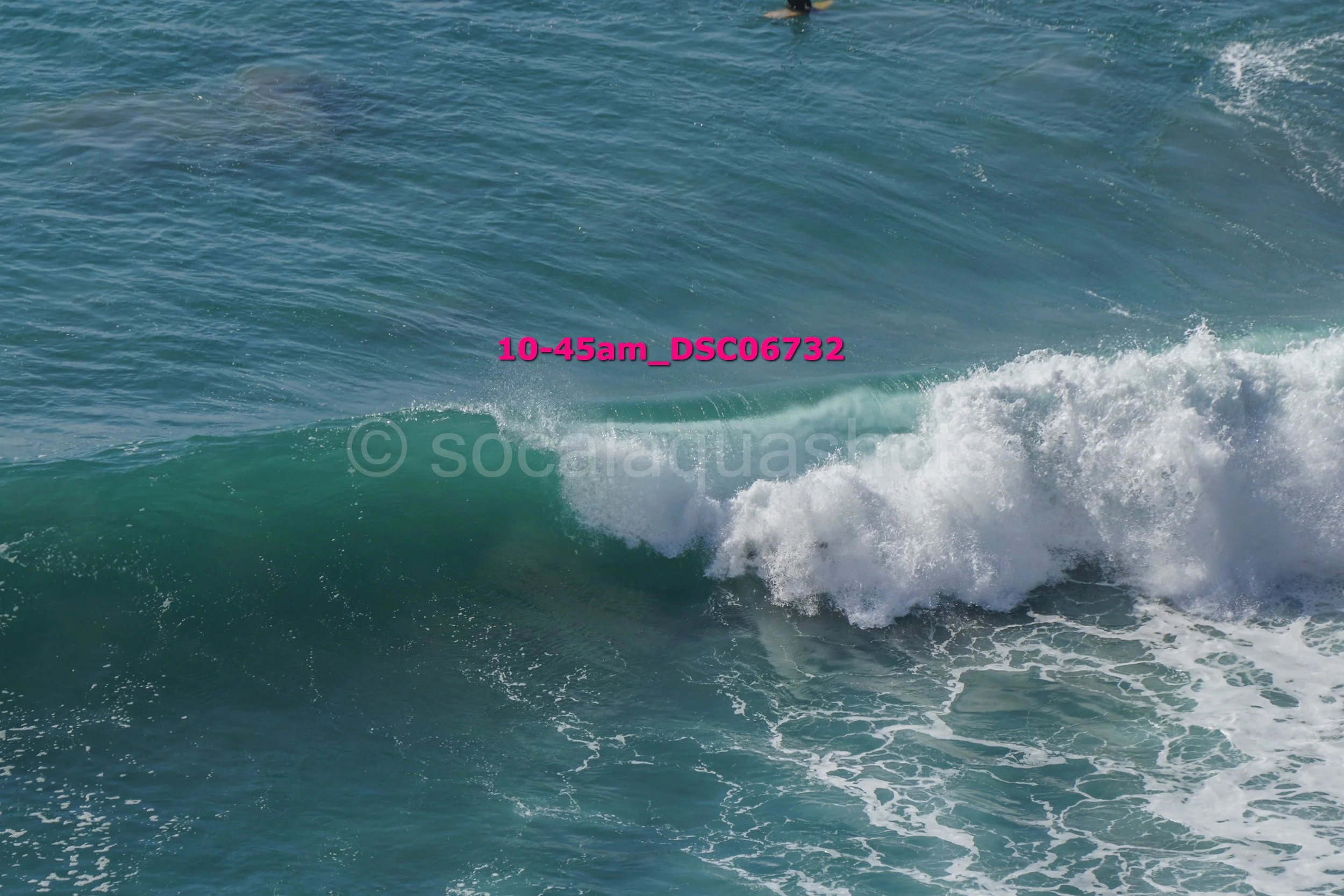 Ocean waves with foam crashing and the sky reflected on the water surface.