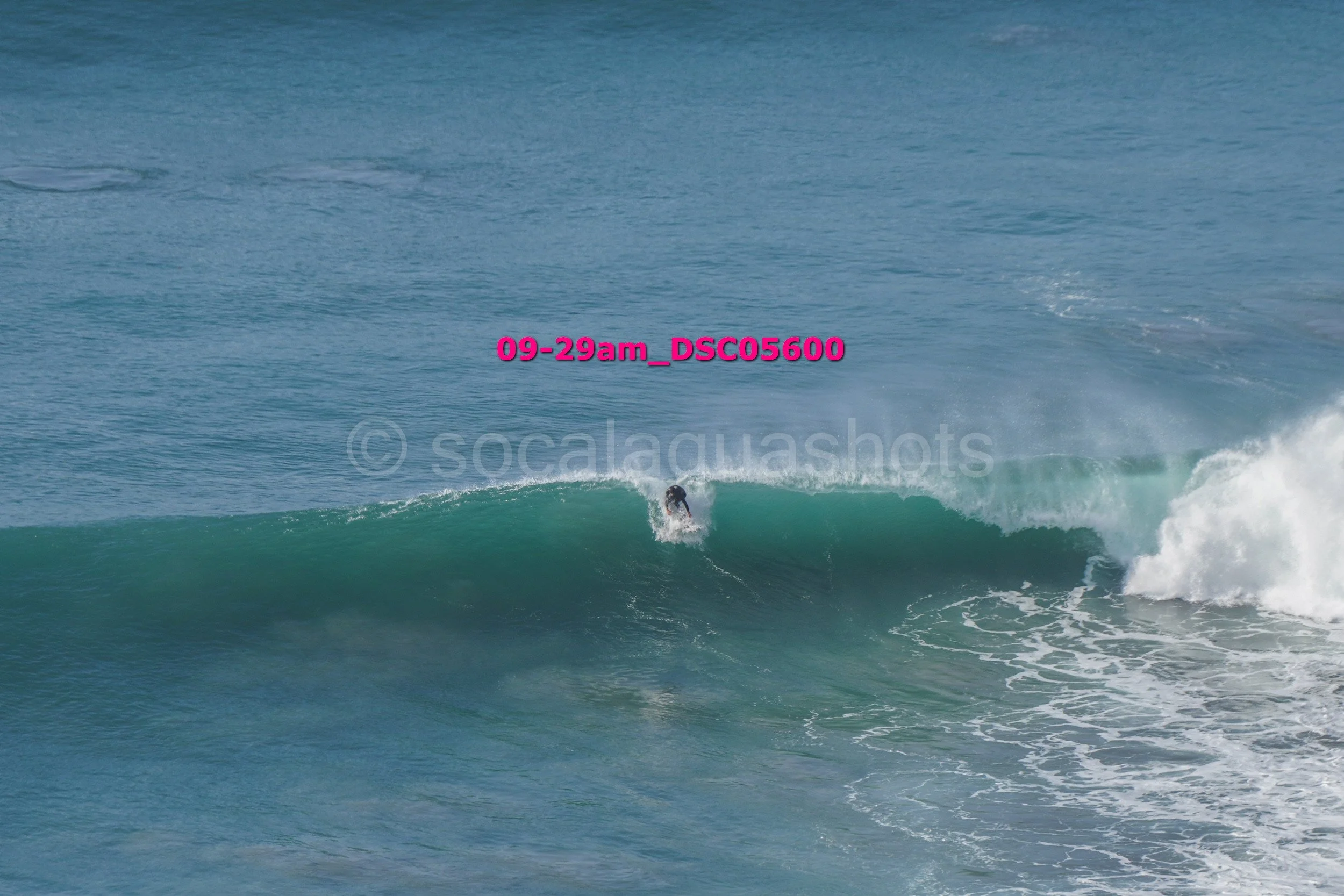 A person surfing on a large wave in the ocean.