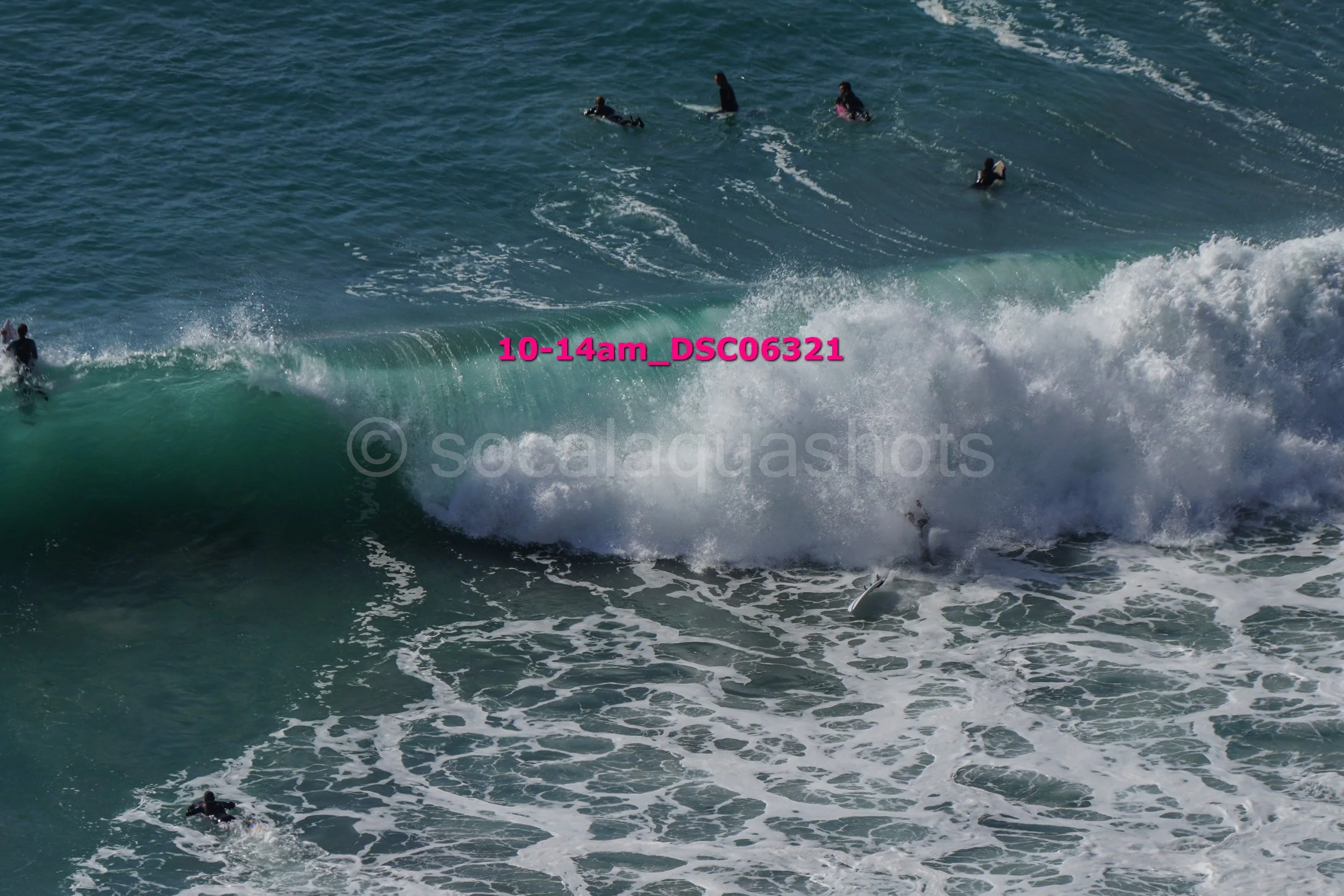 People surfing and swimming in the ocean with large waves