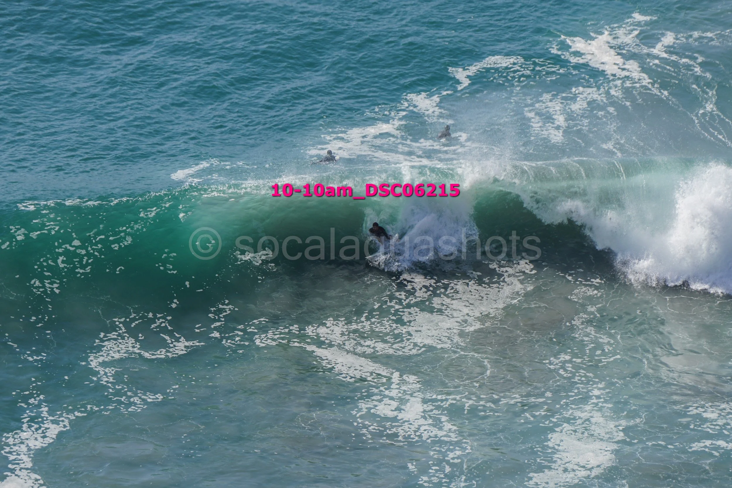 Surfer riding inside a large breaking wave in the ocean