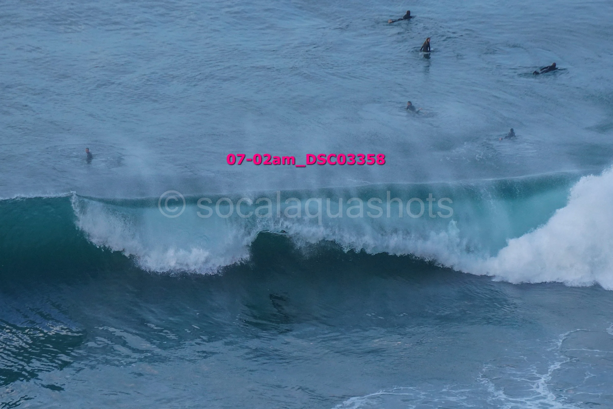 People surfing in the ocean with waves breaking.