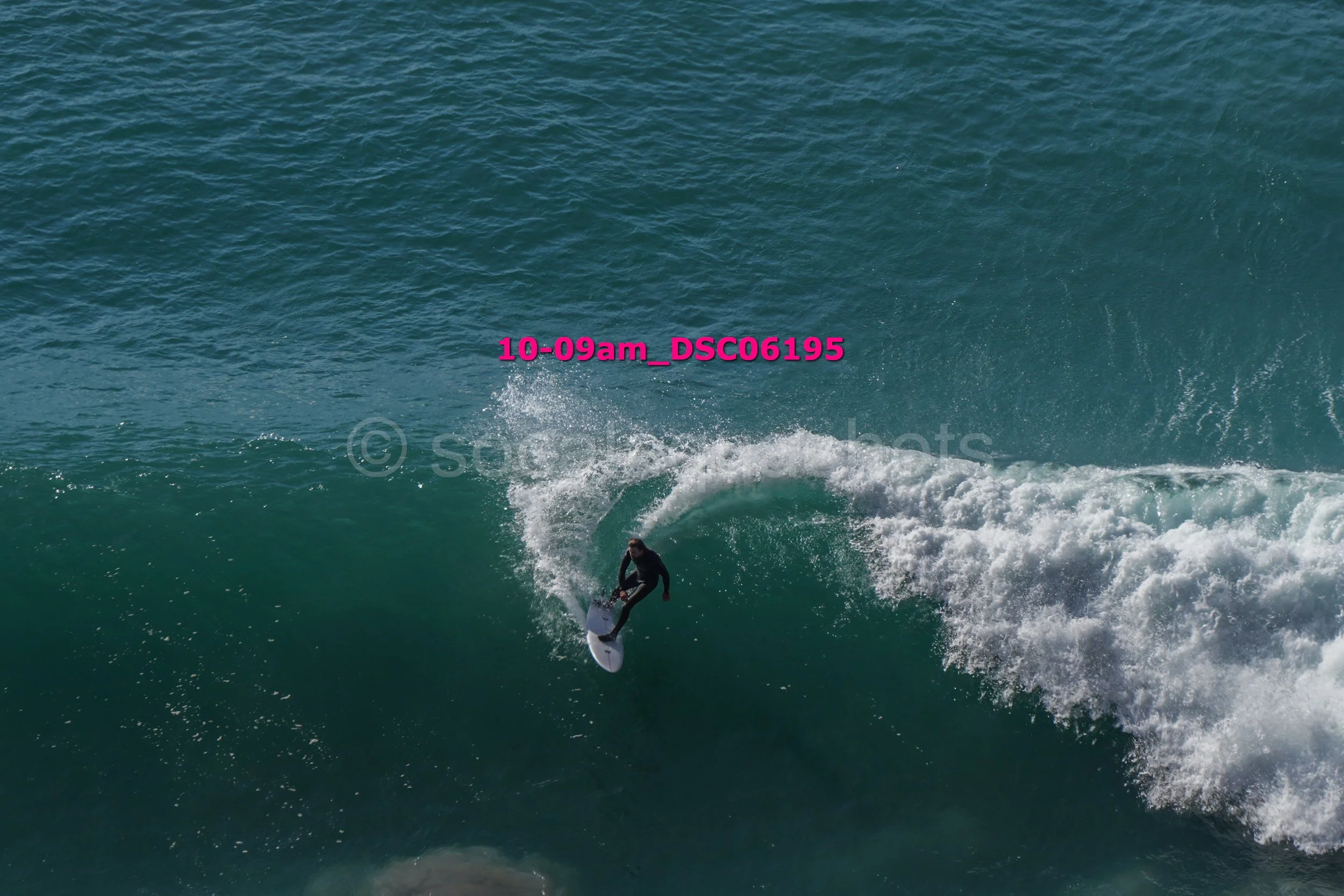 A person surfing on a large wave in the ocean.