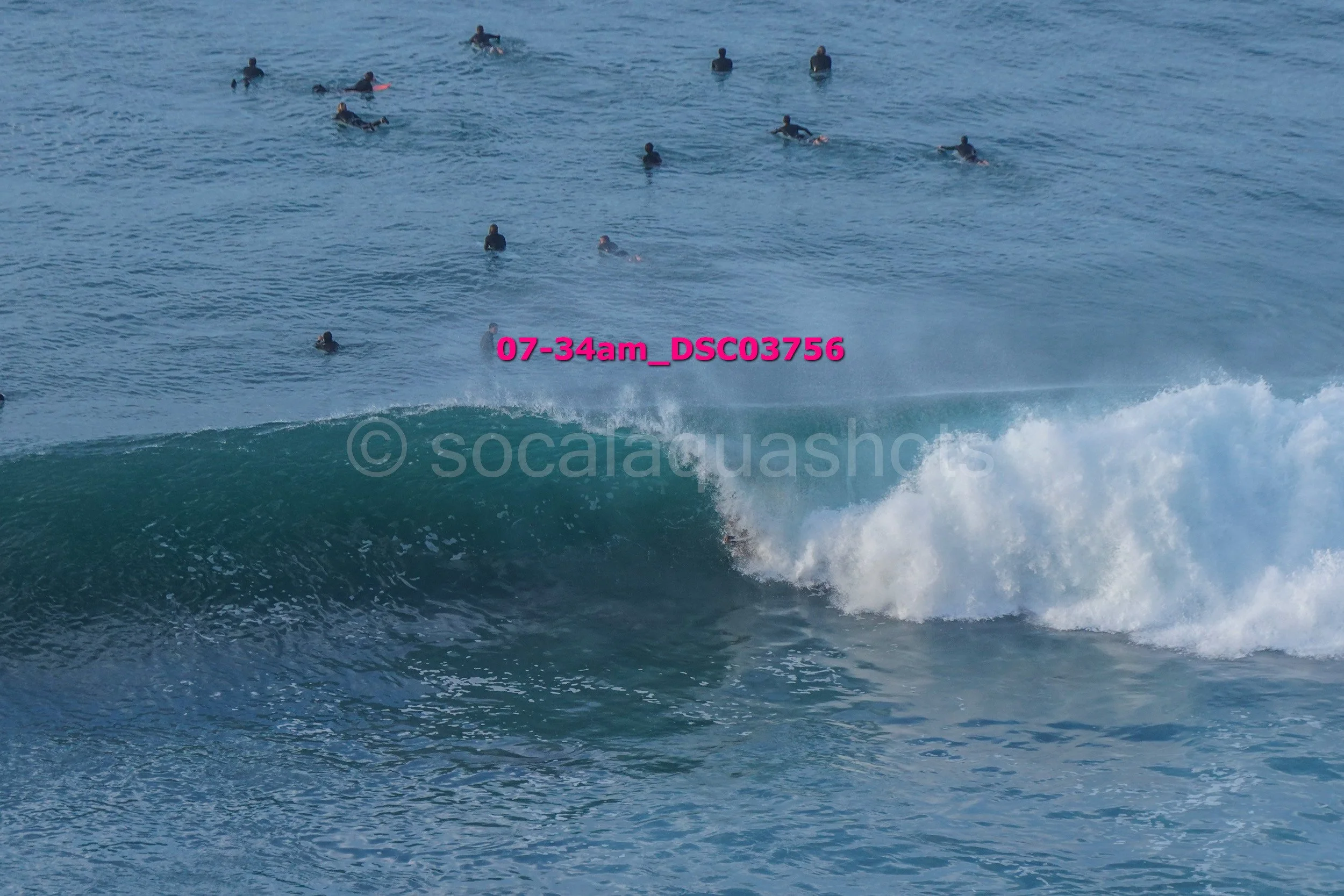 People surfing and swimming in the ocean with large waves