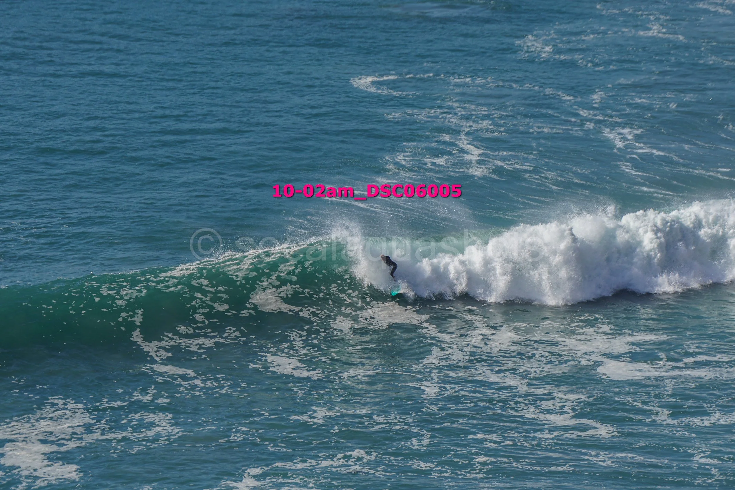 A person surfing on a wave in the ocean.