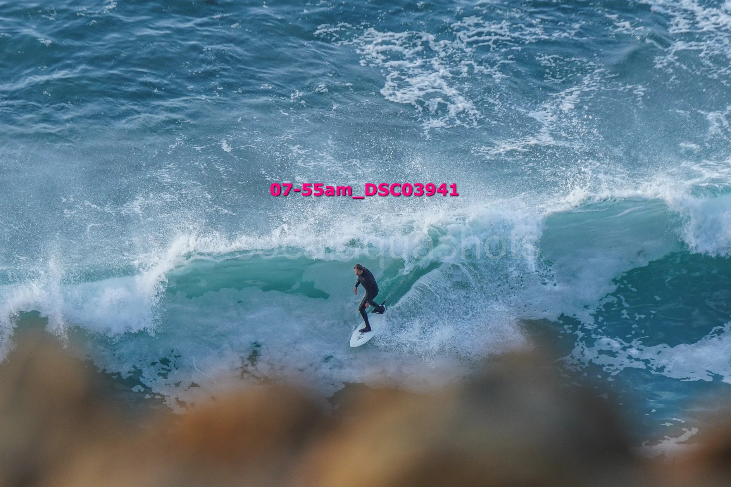 A person surfing on a large wave in the ocean.