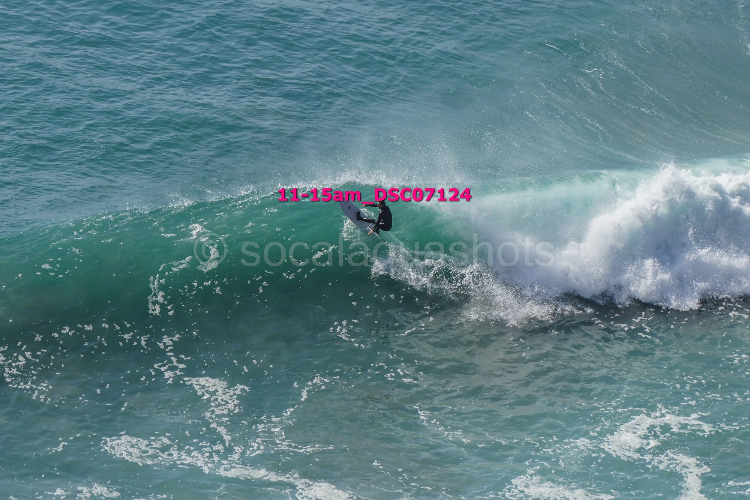 A person surfing on a large wave in the ocean at daytime.
