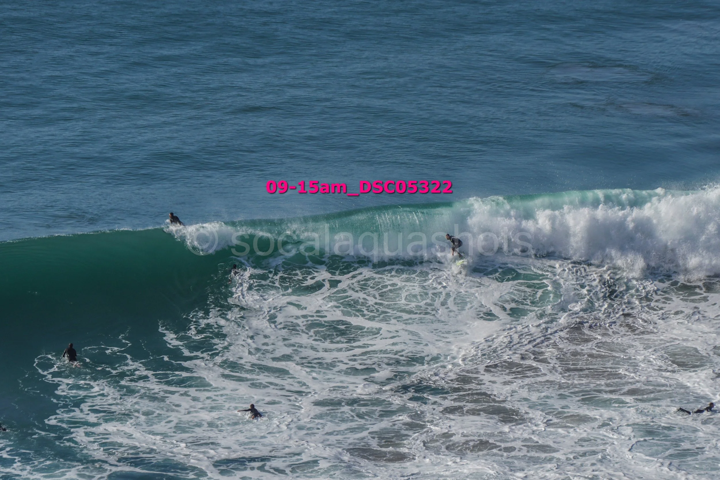 People surfing on large waves in the ocean.
