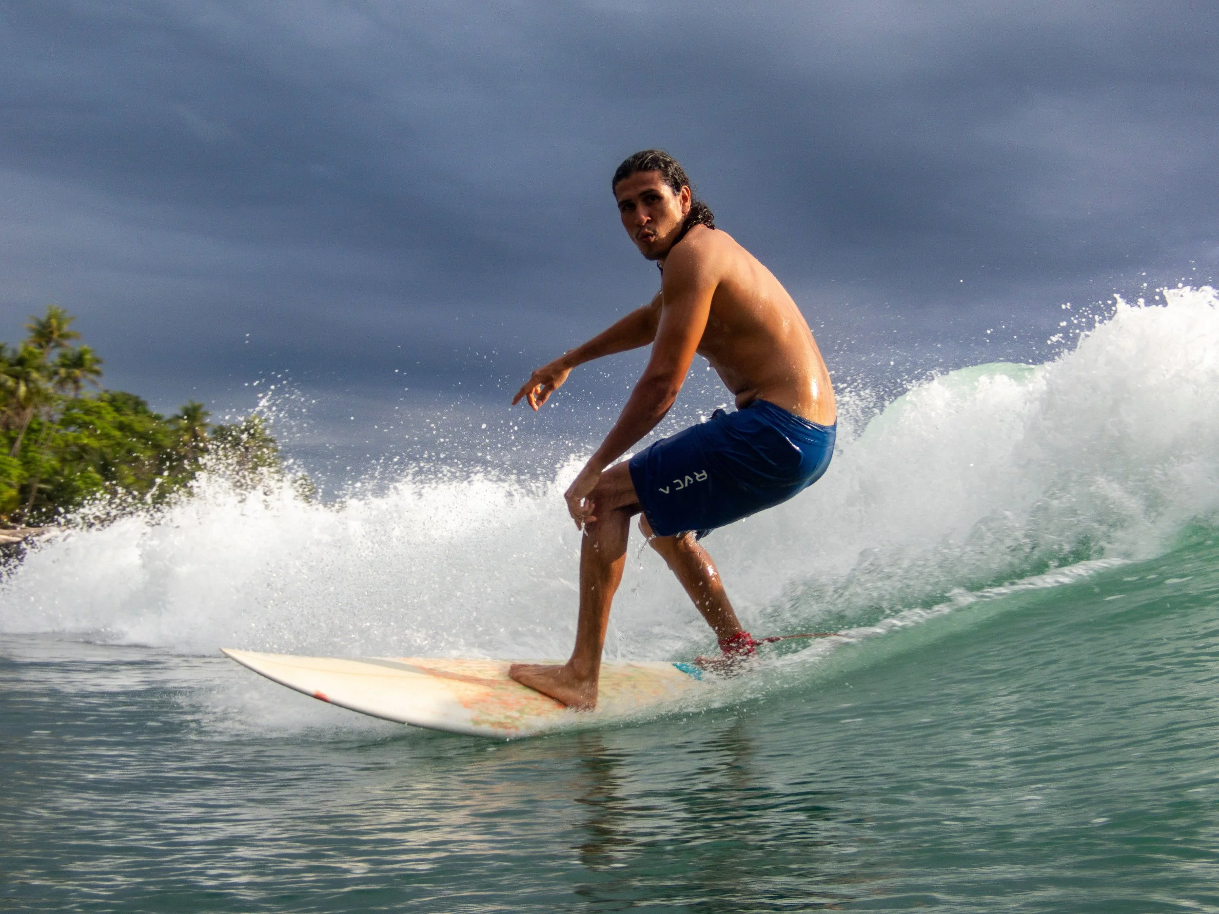 Surfer riding a wave in tropical ocean