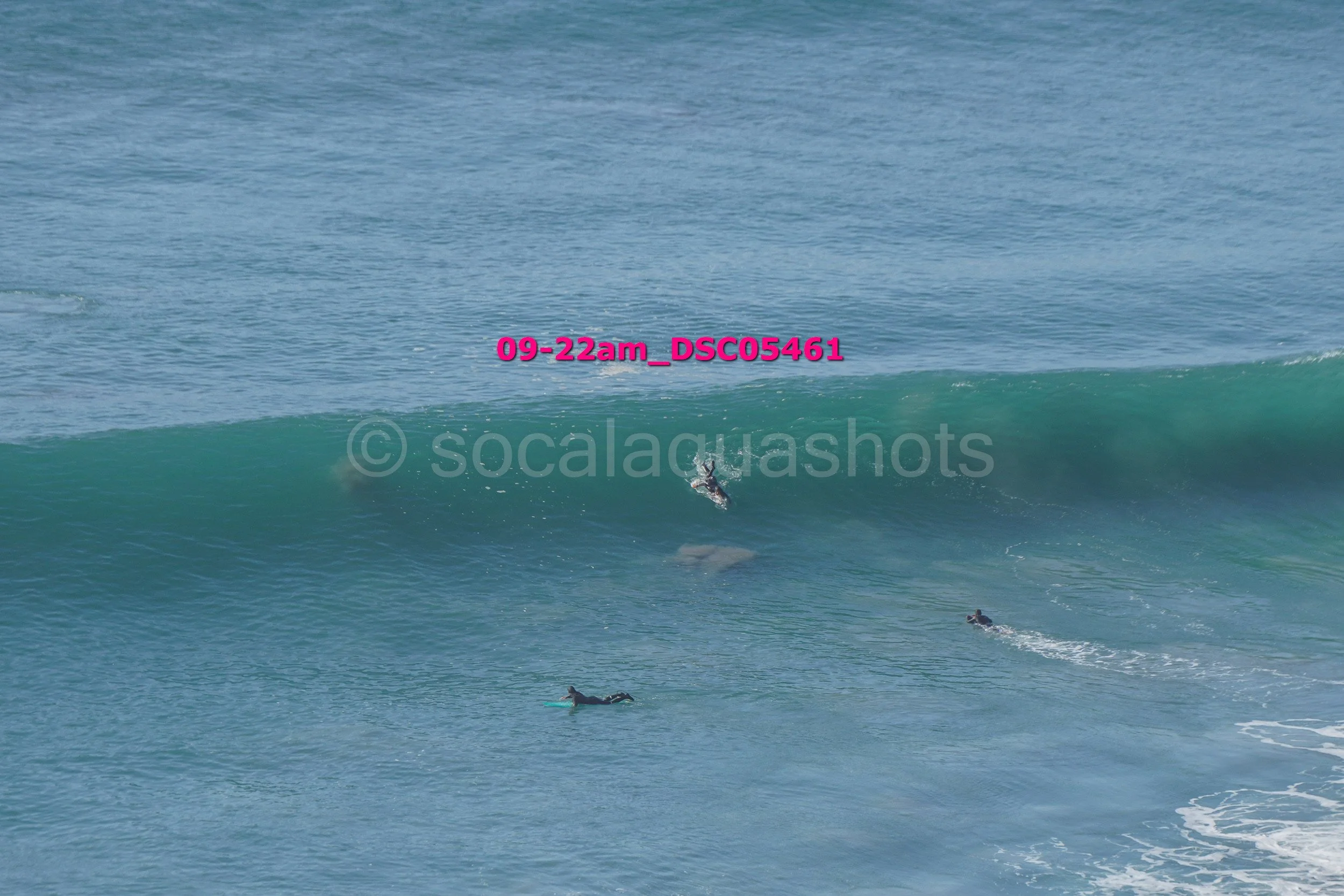 Surfers riding a large wave in the ocean