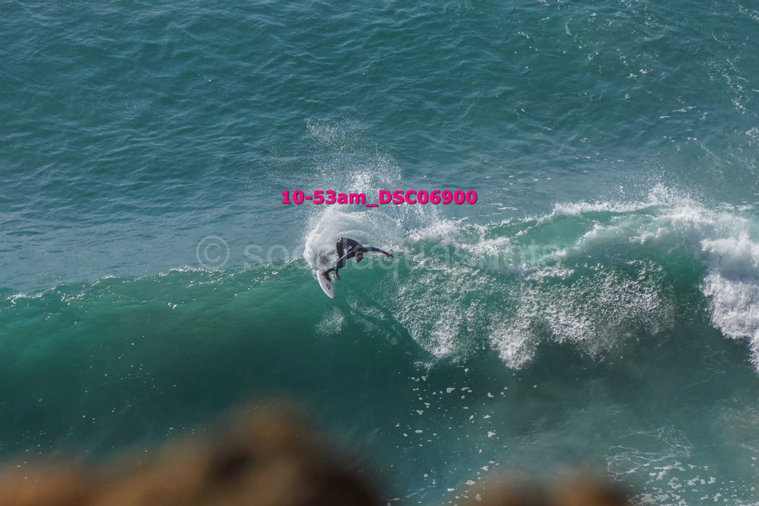 A surfer riding a wave in the ocean, with water splashing around them.