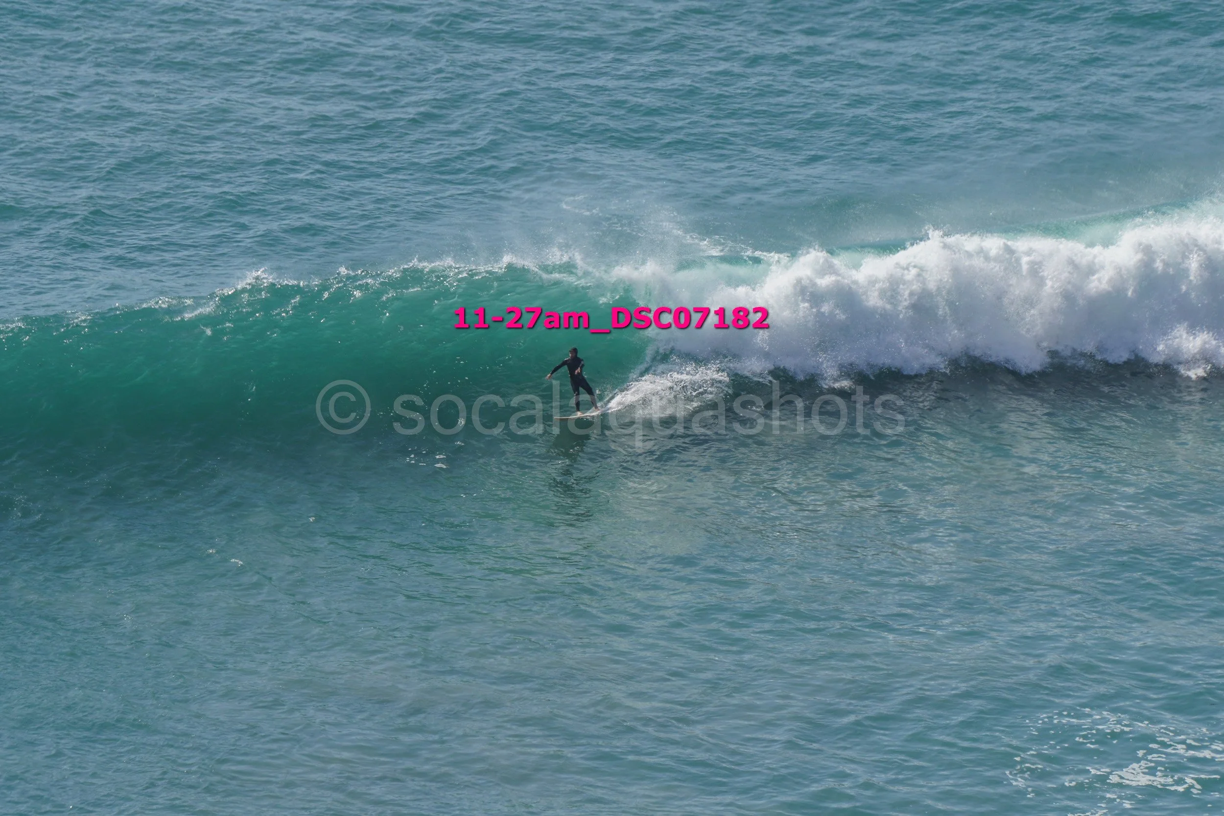 A person surfing on a large wave in the ocean.