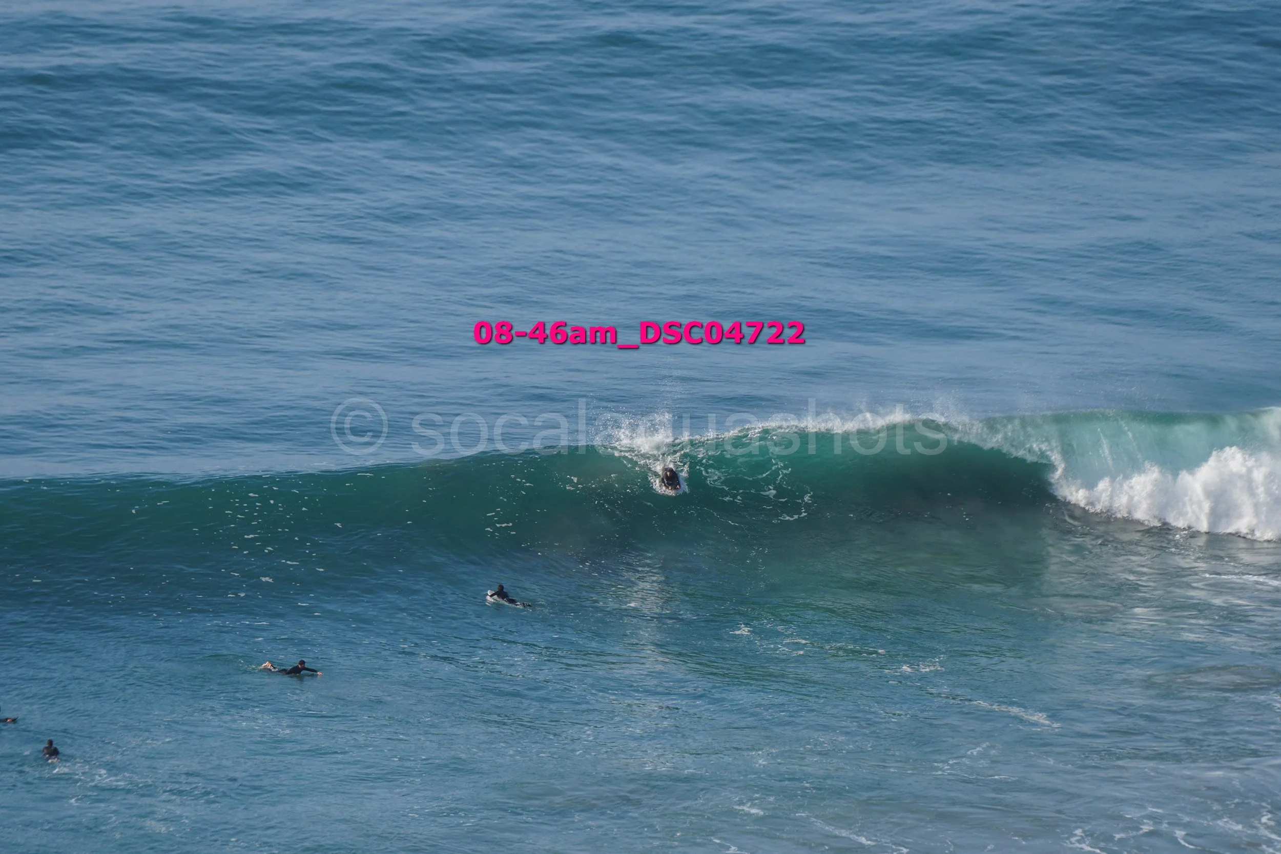 People surfing in the ocean with waves and blue water during daytime.