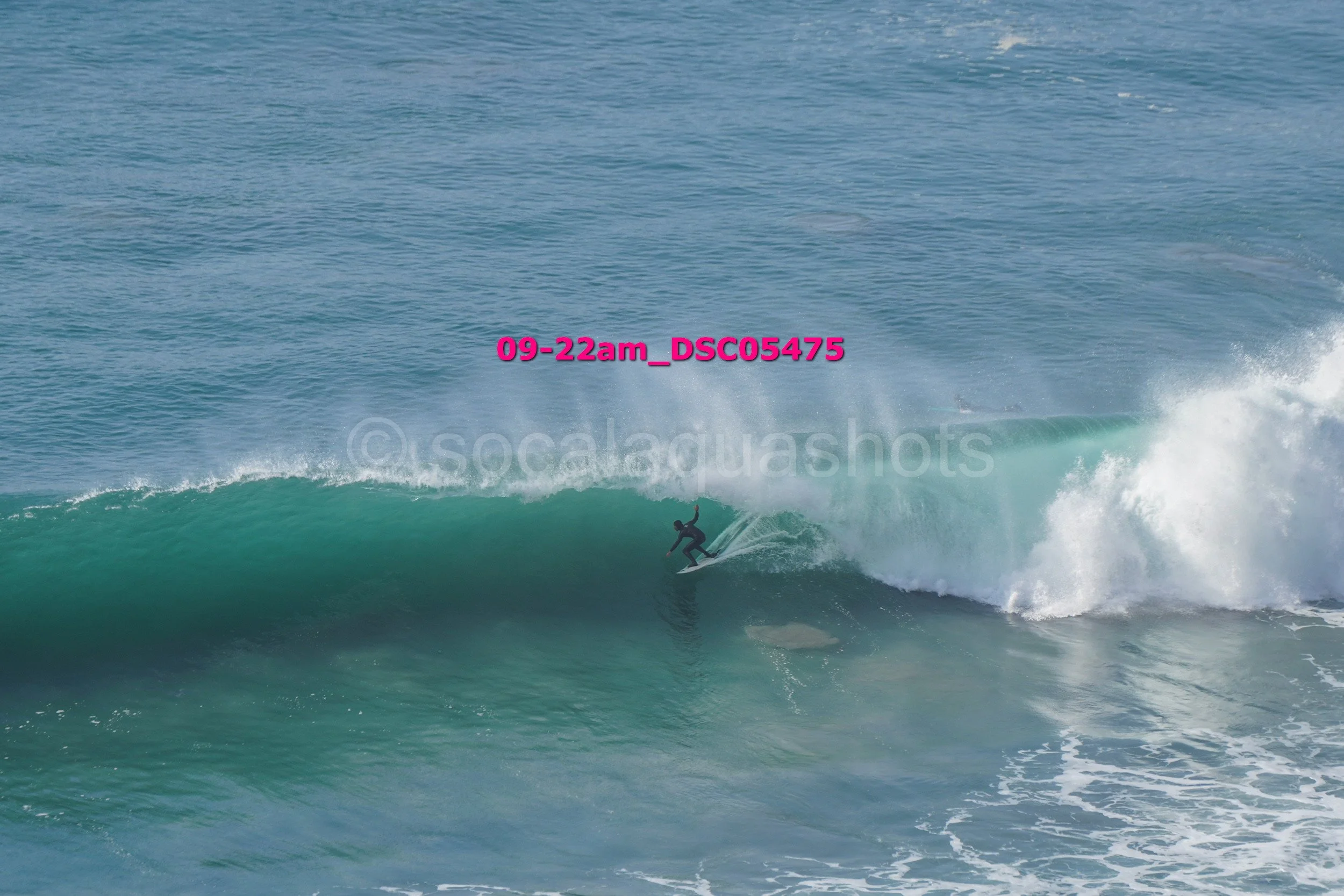 A person surfing on a wave in the ocean during daylight.