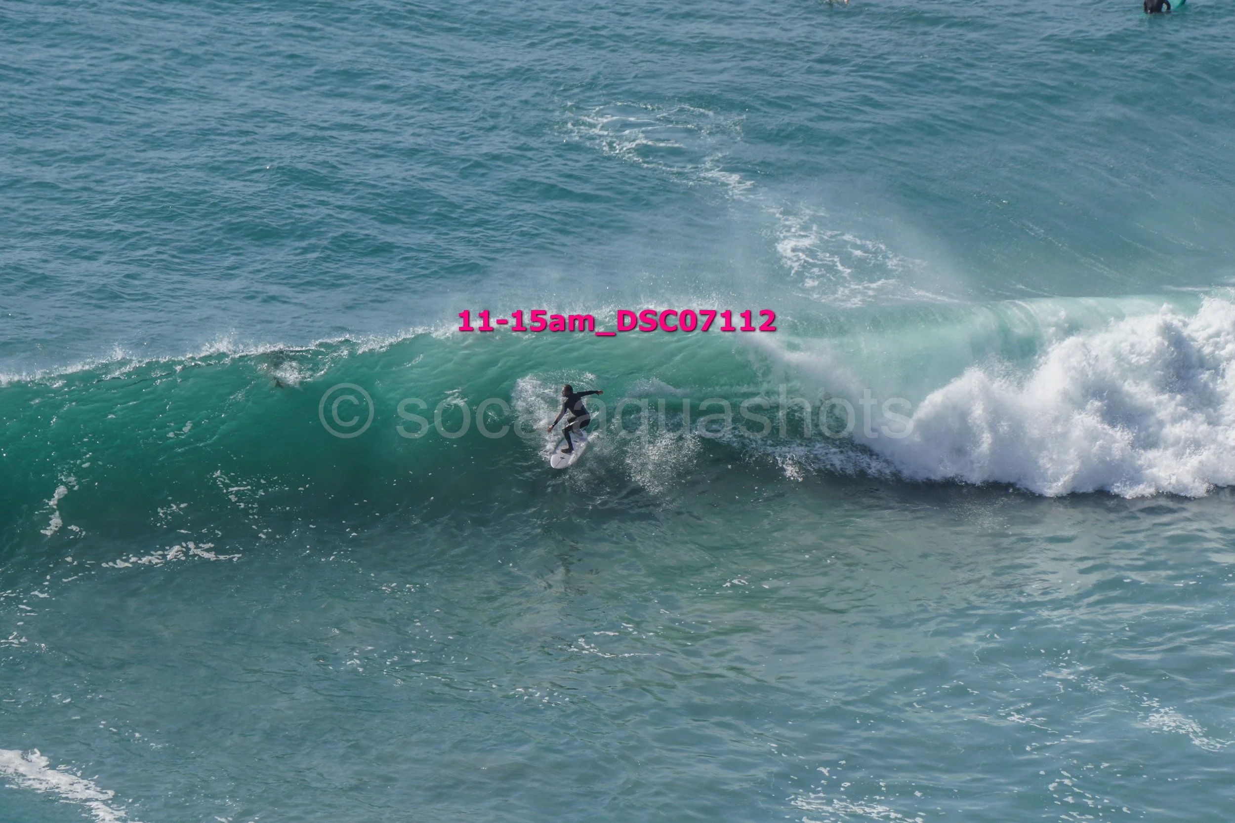A surfer riding a wave in the ocean on a clear day.