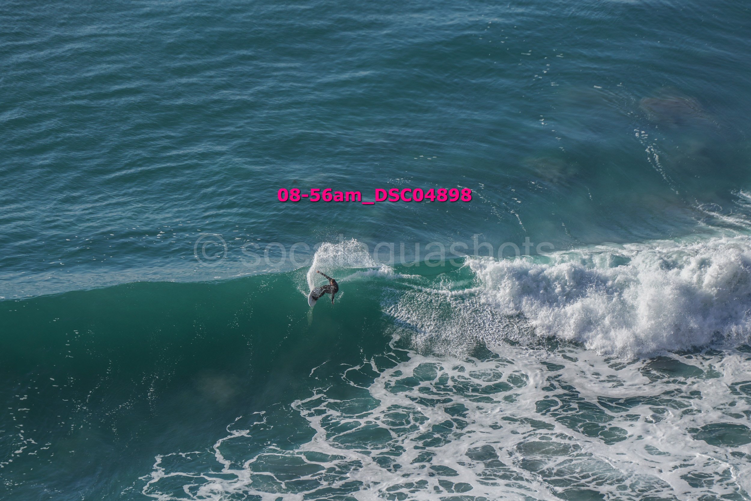 A person surfing on a wave in the ocean during daytime.