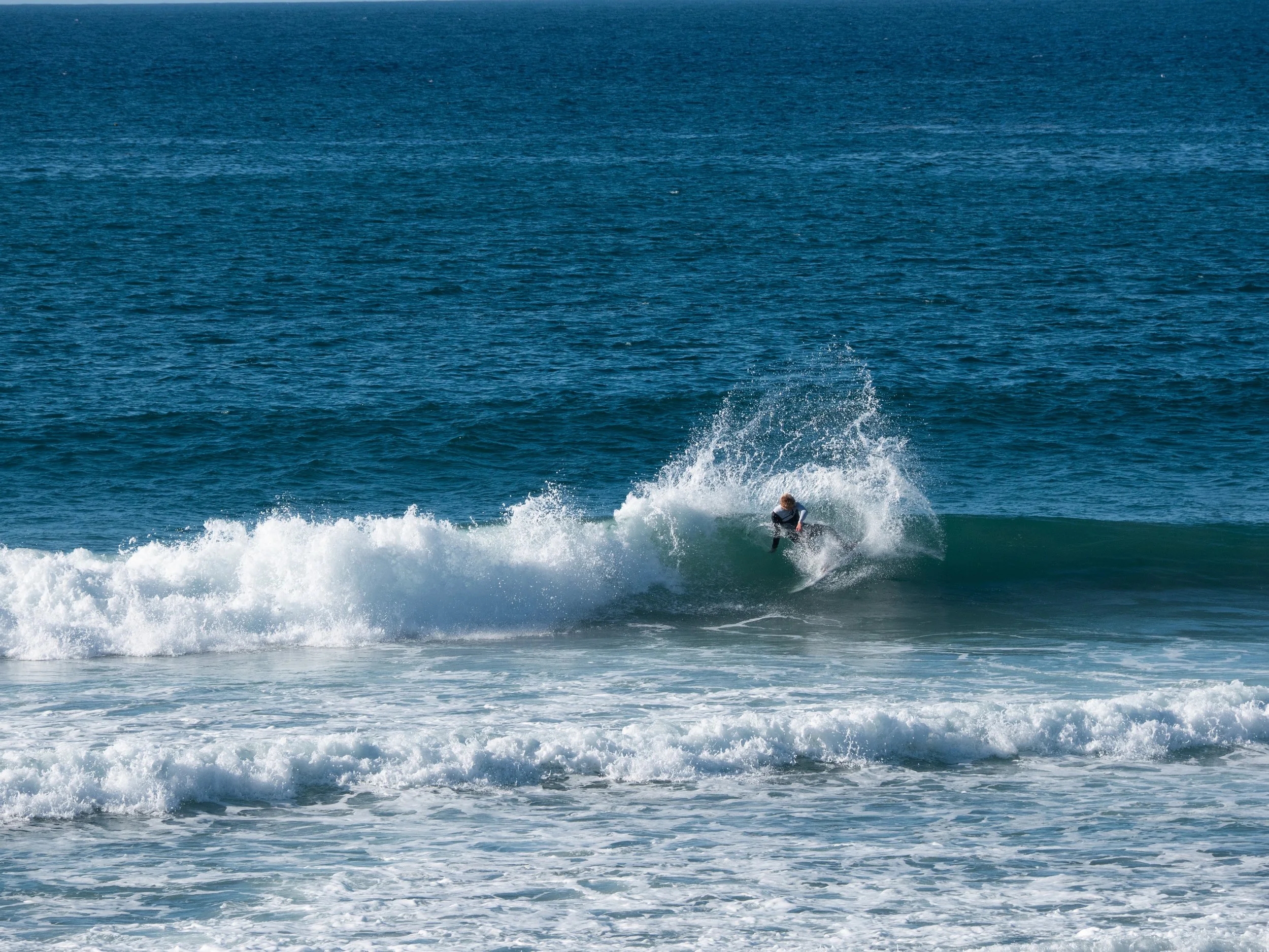 A person surfing on a wave in the ocean.