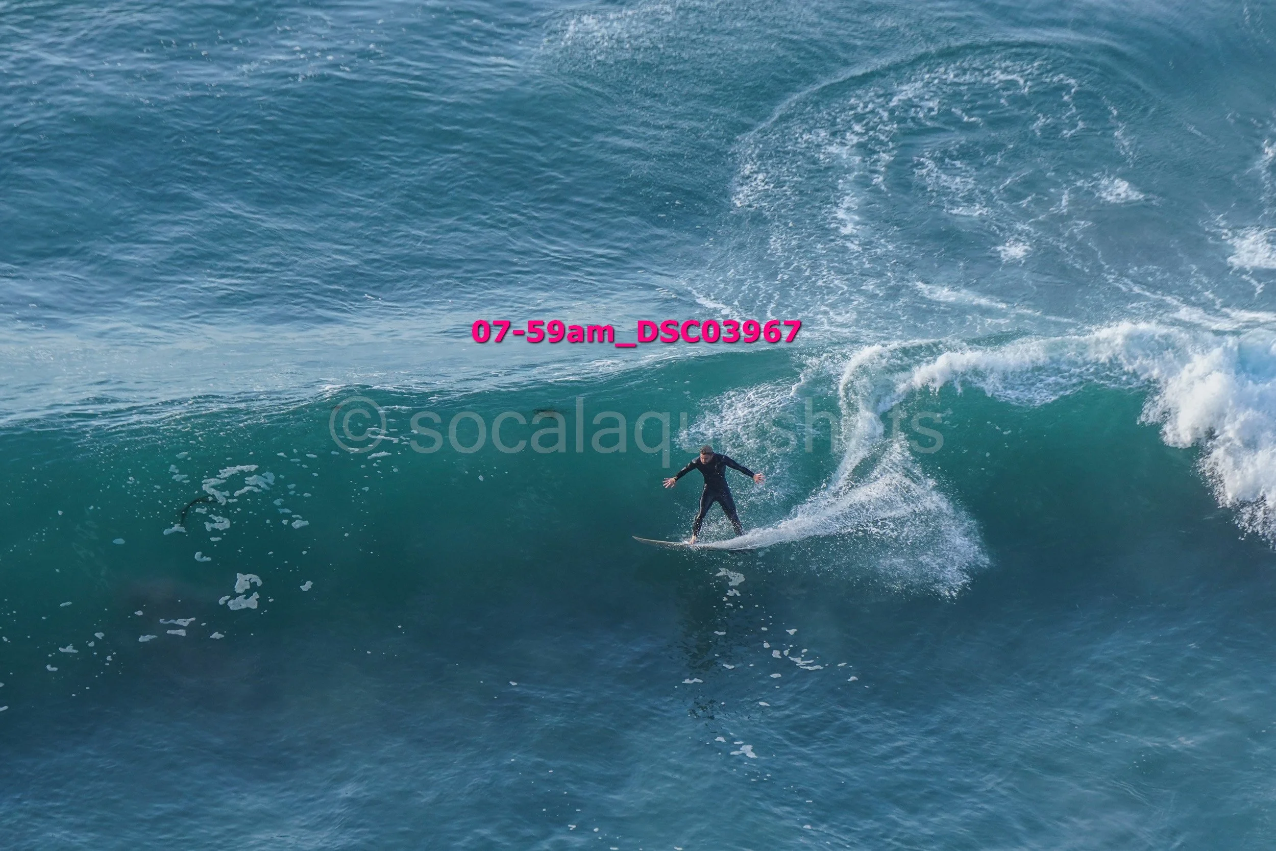 A person surfing on a large ocean wave.