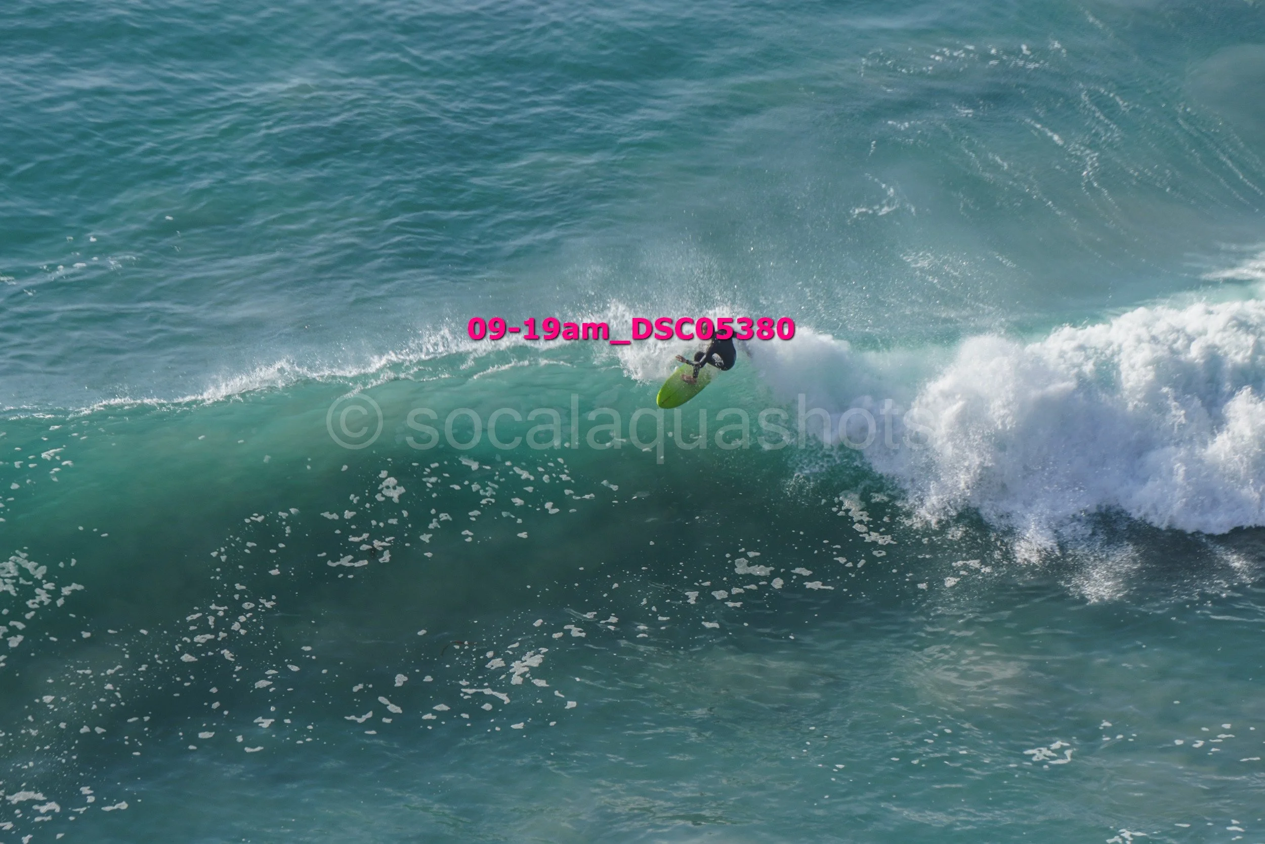 A person surfing on a large wave in the ocean, captured mid-turn.