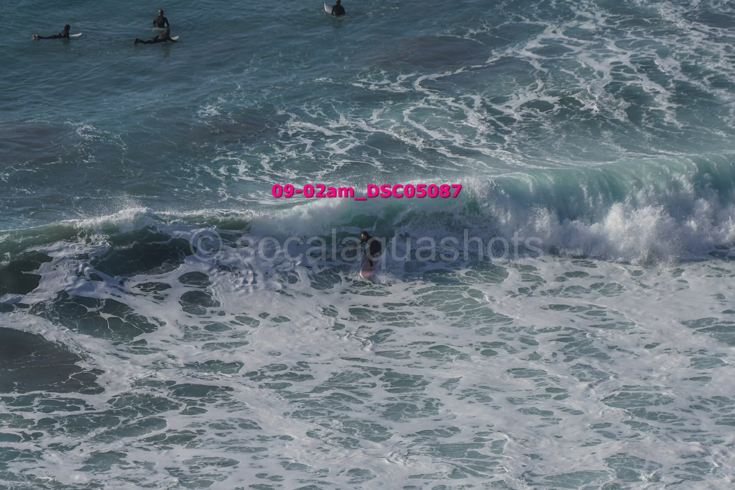People surfing in the ocean with waves and surfboards.