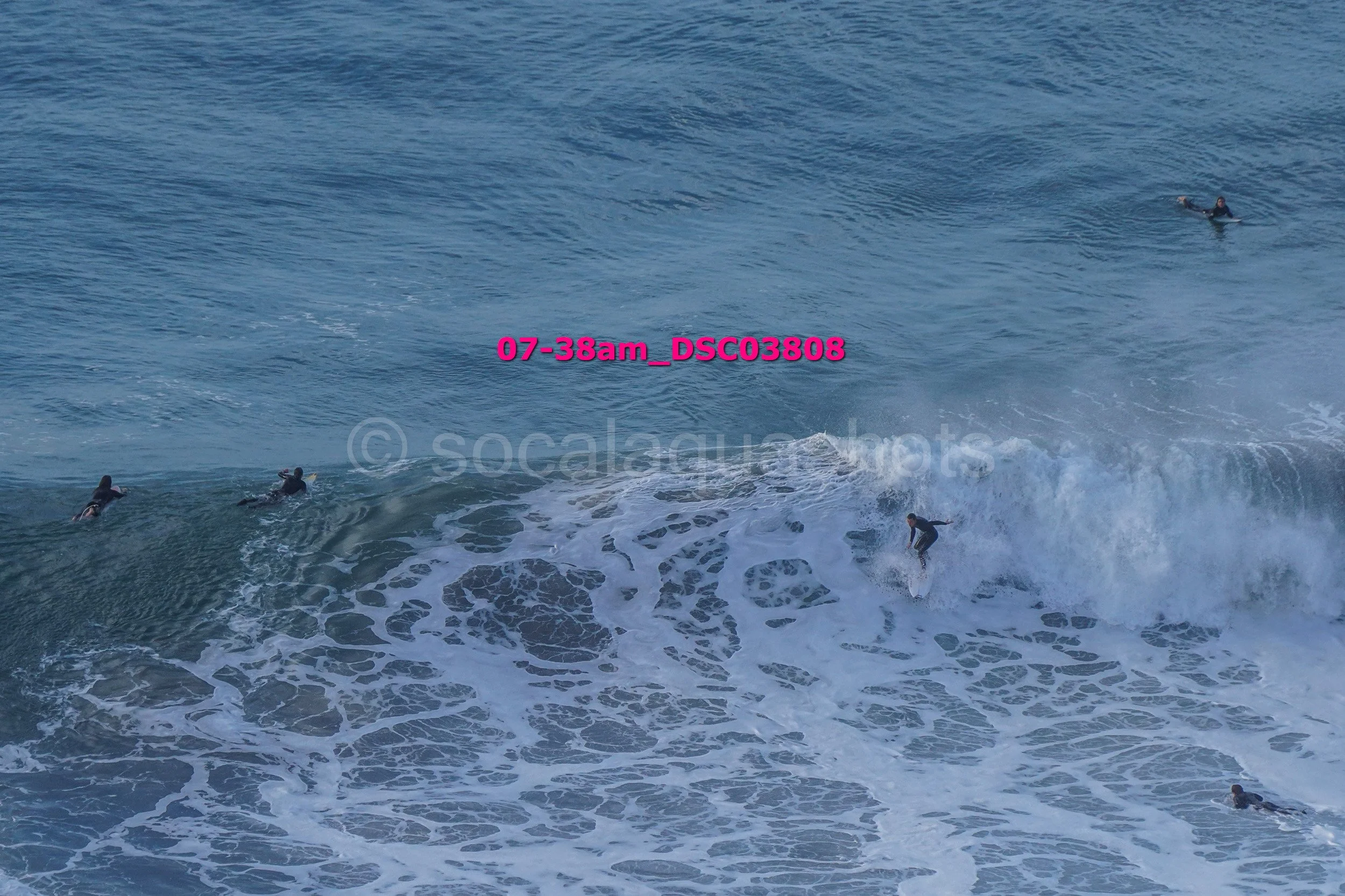 Surfers in the ocean riding waves and swimming in the water.
