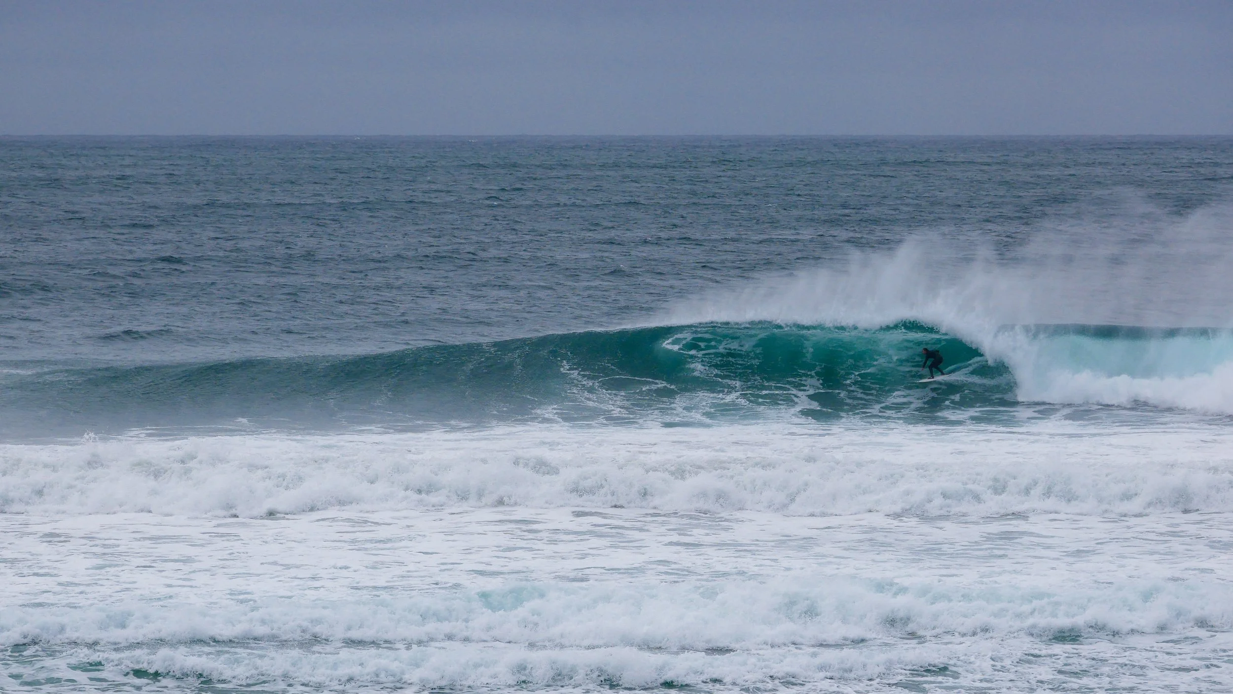 Surfer riding big wave in ocean