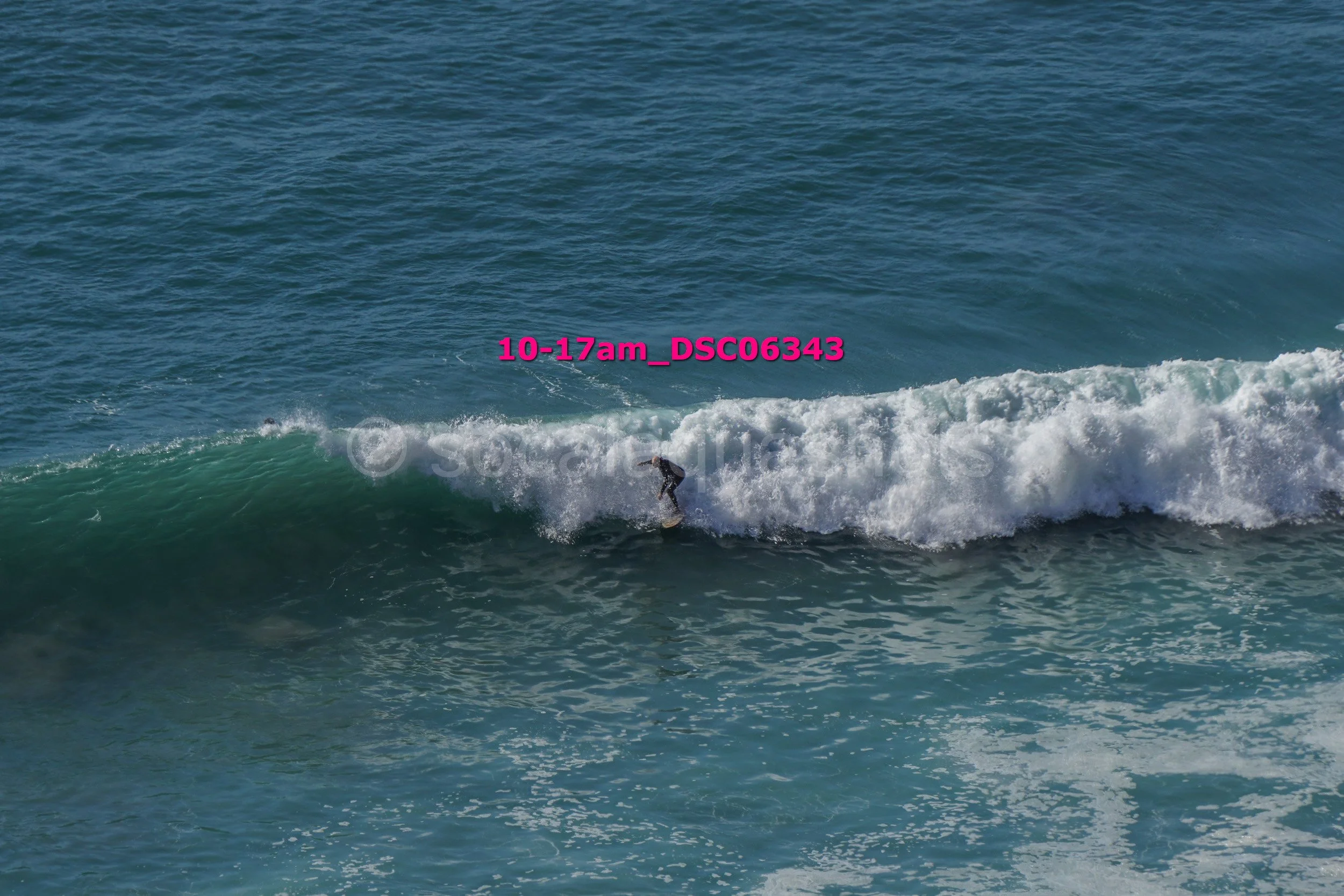 A person surfing on a wave in the ocean during daytime.