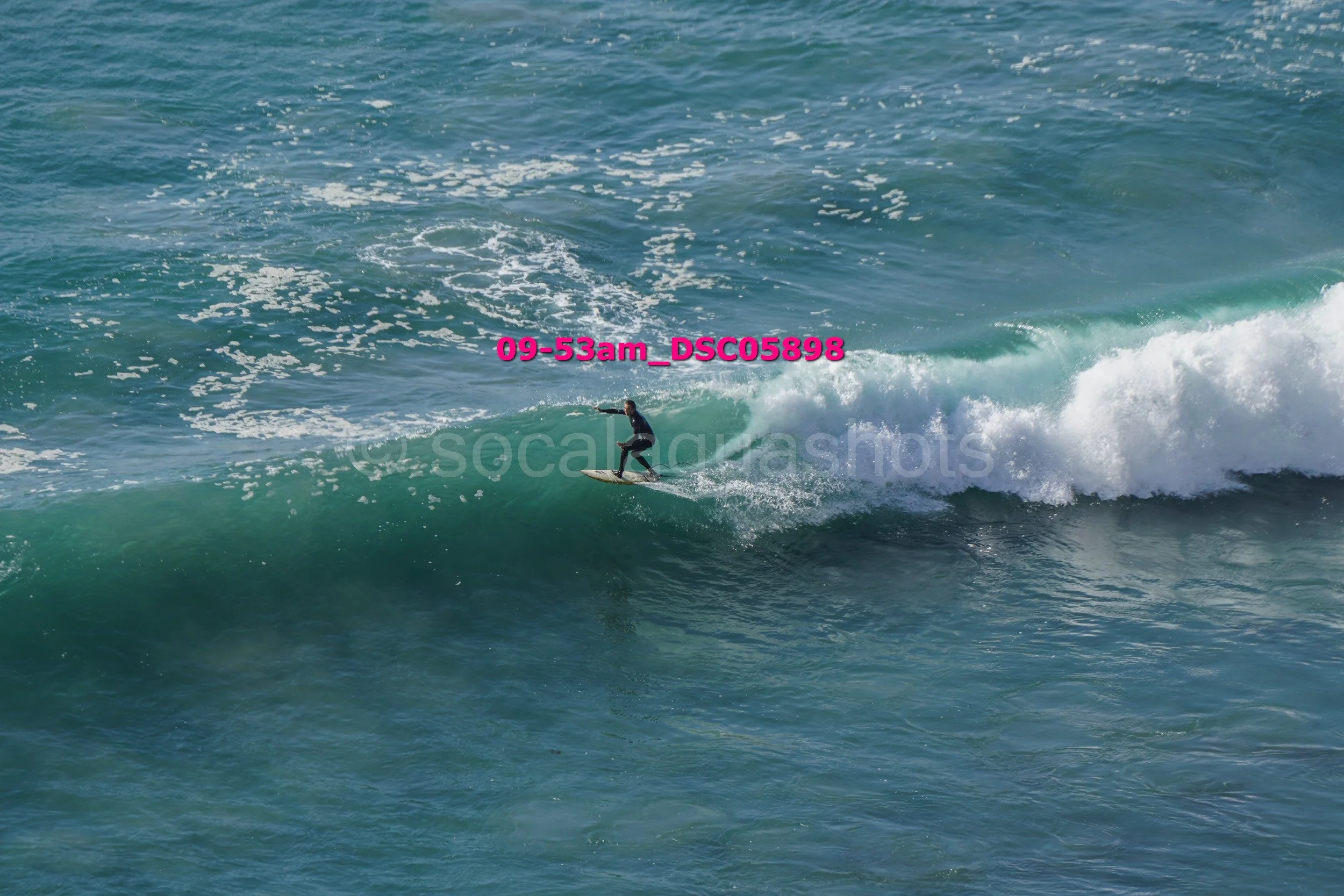 A person riding a surfboard on a wave in the ocean.