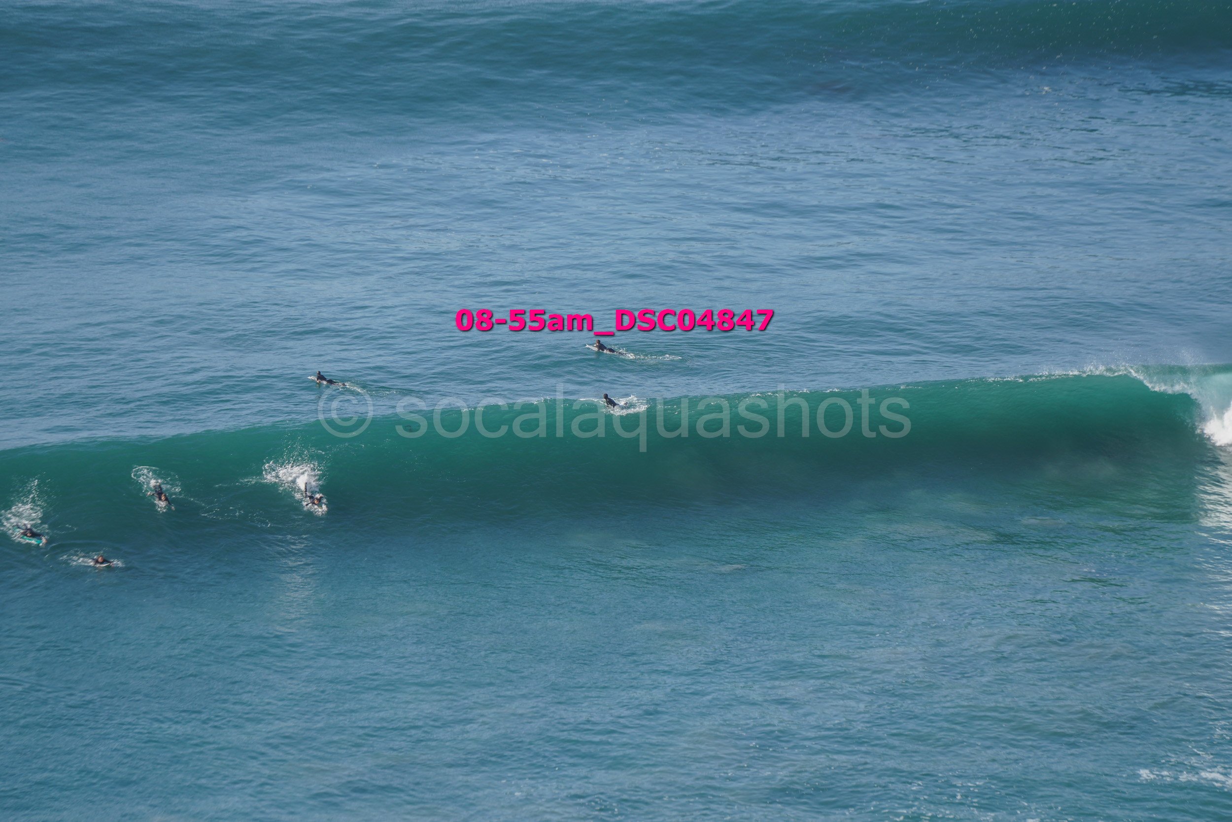 Group of surfers riding a large wave in the ocean