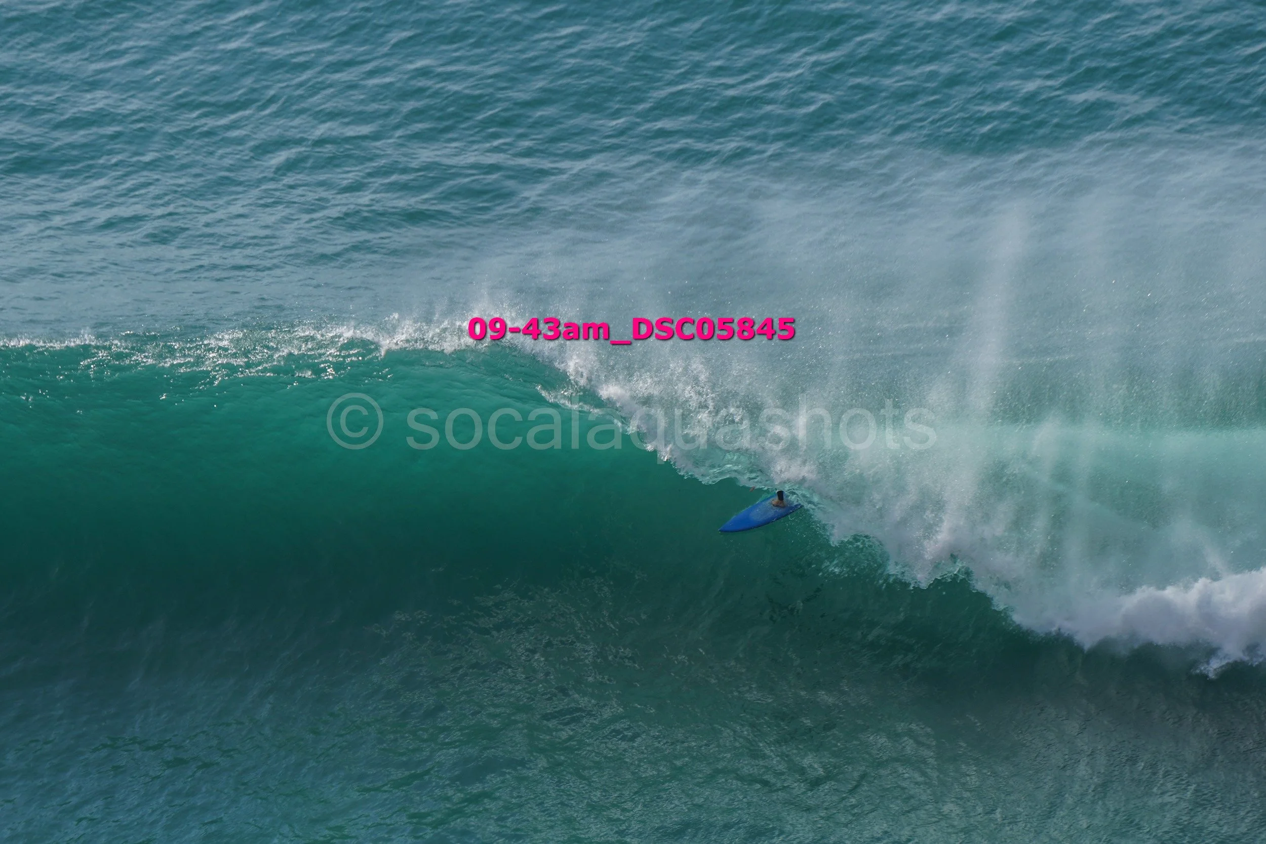 A surfer riding inside a large ocean wave.