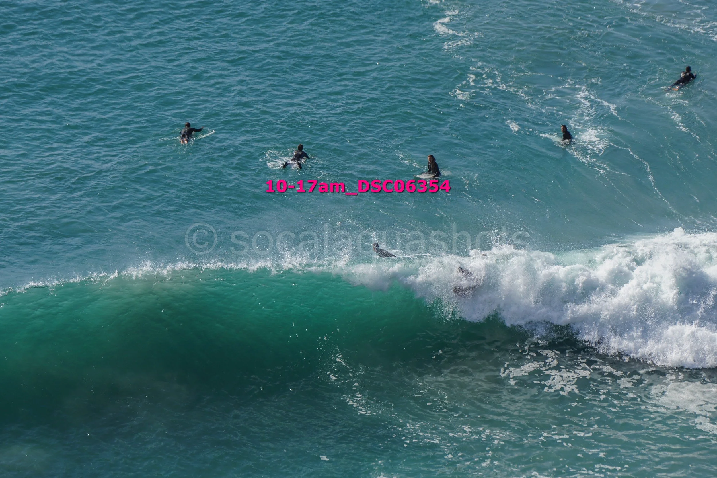 Surfers on the ocean waves with one surfer falling or diving from their surfboard.