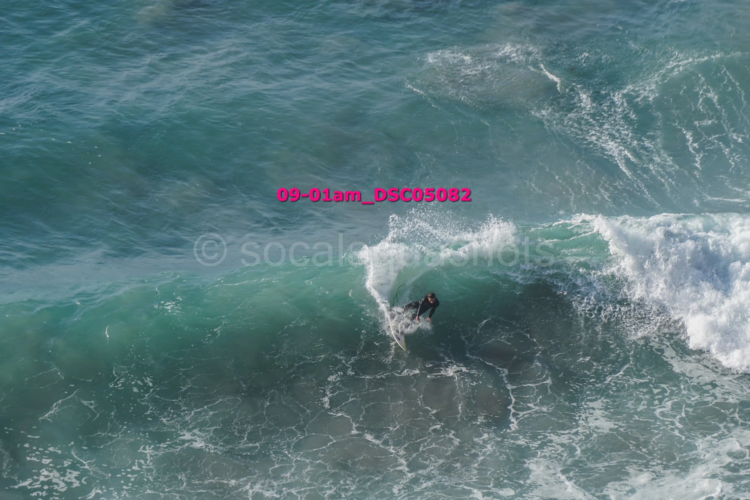 A person surfing on a large wave in the ocean.
